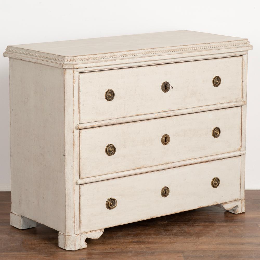 Gustavian white painted chest of three drawers with beaded trim along top.
Newer professionally applied and layered white painted finish, lightly distressed to fit age and grace of chest.
Restored, strong and stable, drawers function; top drawer