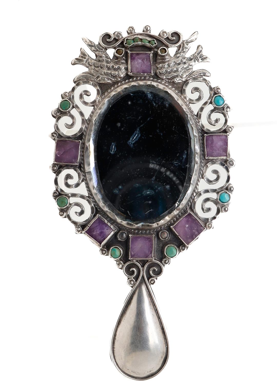 A fine antique Mexican sterling silver hand mirror.

In sterling silver.

By Gustavo Martinez (in the style of Matl or Matilde)

Set throughout with turquoise cabochons and faceted amethysts. The silver is fashioned into various spirals with two