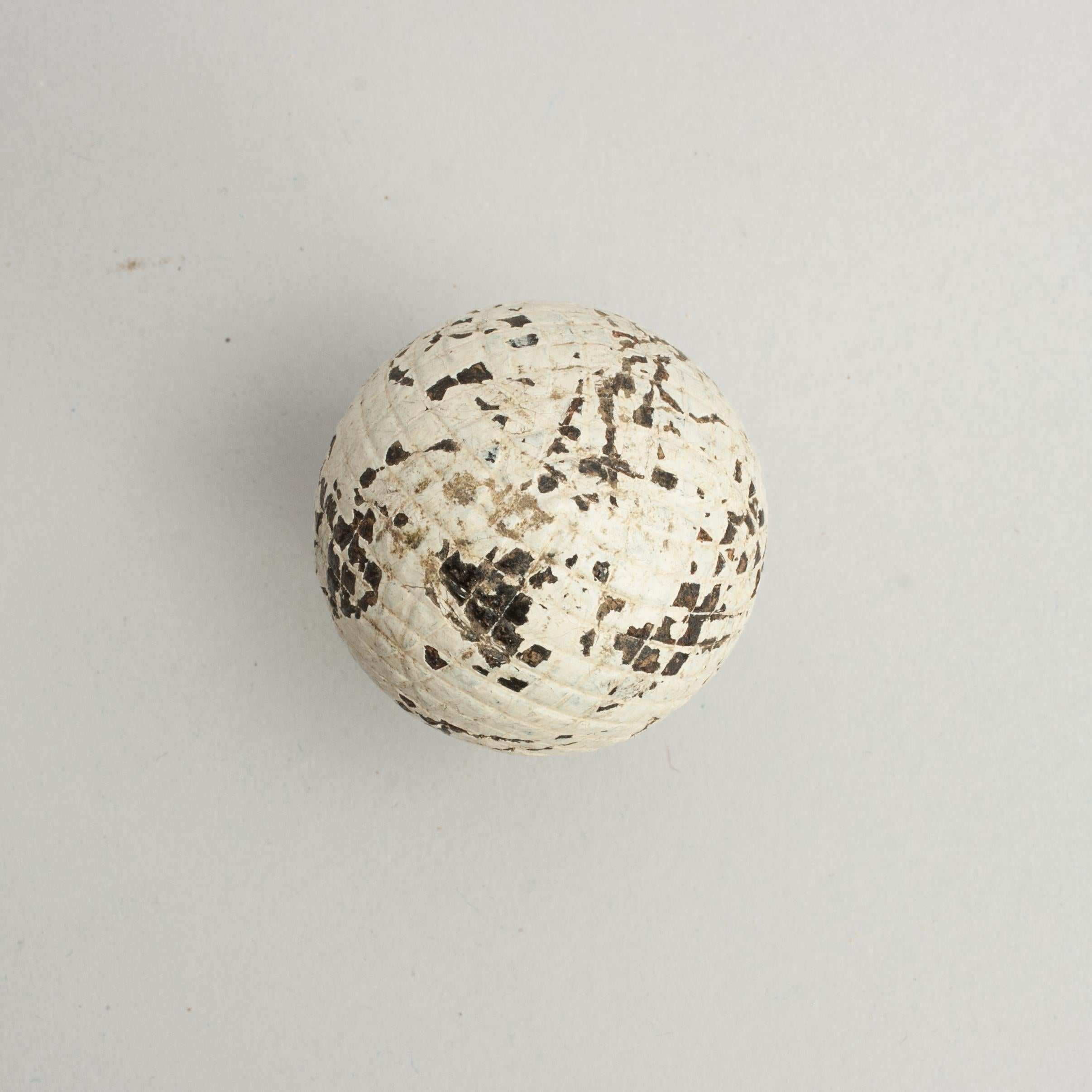 Unnamed Mesh Pattern Gutty Golf Ball.
A moulded solid square mesh patterned gutta percha golf ball in used condition. The 1890's Gutty ball still has the lots of the original white paint.

The ball is approximately 1 11/16 inch in diameter (4.3