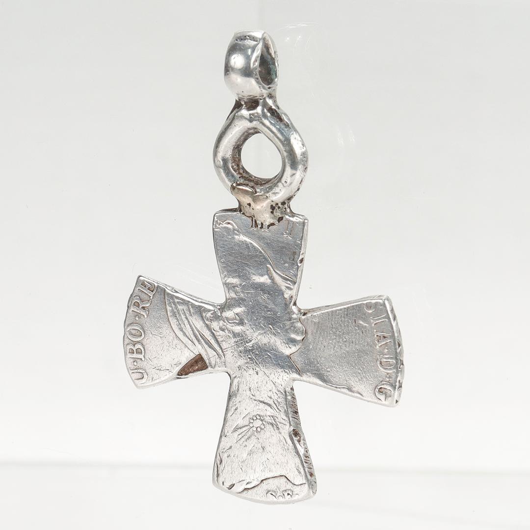 A fine antique cross.

Made from a Maria Theresa thaler silver coin cut into the shape of a cross.

With an integral bail.

Simply a great piece of jewelry made from the currency of the Habsburg monarchy! 

It appears to retain traces of gilding to