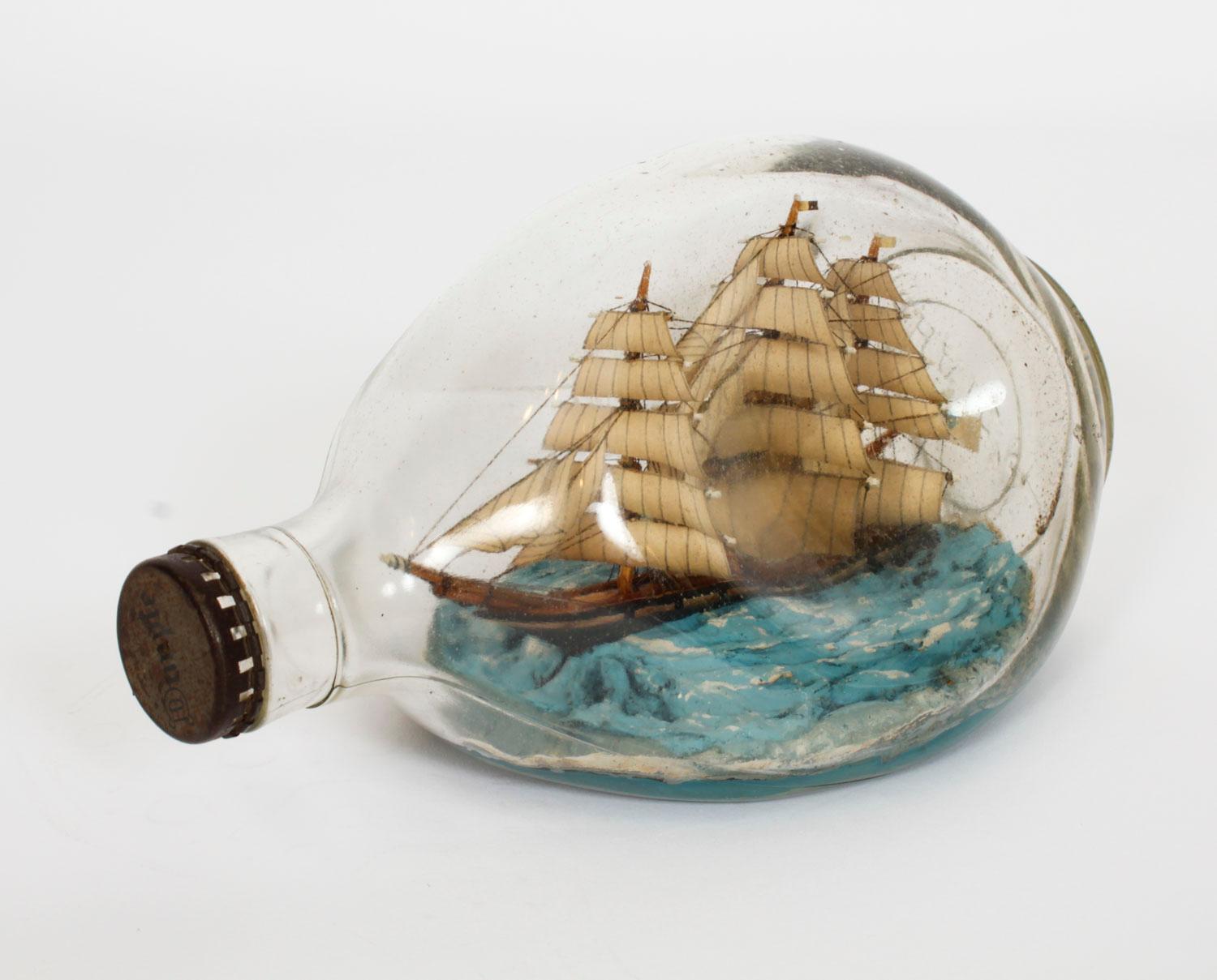 Antique ship in glass Haig's Dimple whiskey bottle with sealed cork top, circa 1920.

The three masted vessel on simulated sea with wooded hull and deck on a simulated blue sea, the bottle is marked Dimple on the lid and Haig's