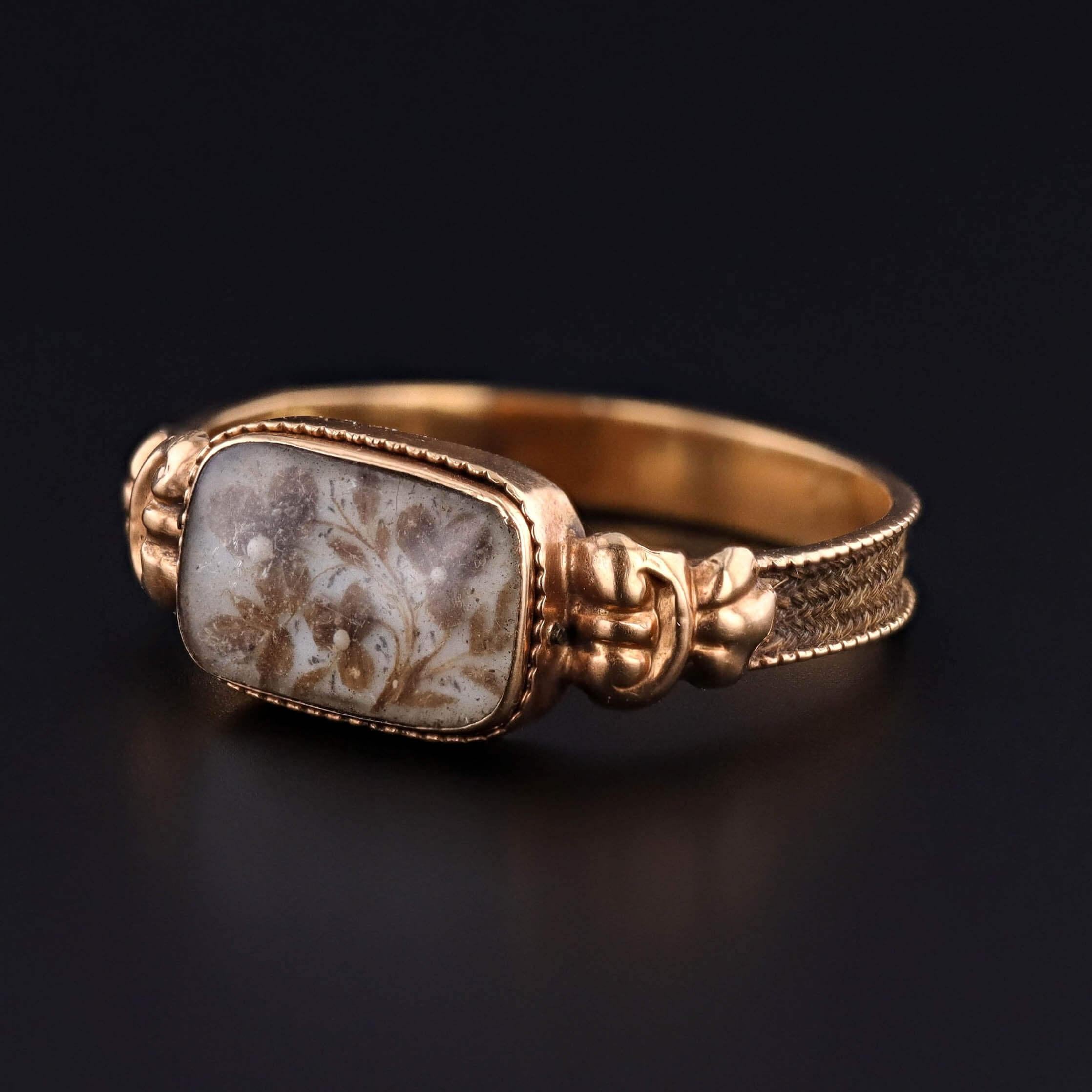 Un raro e sentimentale anello vittoriano del 1860-1870, con viole del pensiero squisitamente lavorate e conservate sotto un pannello di vetro a cupola. Il delicato motivo floreale, che simboleggia il ricordo e il 