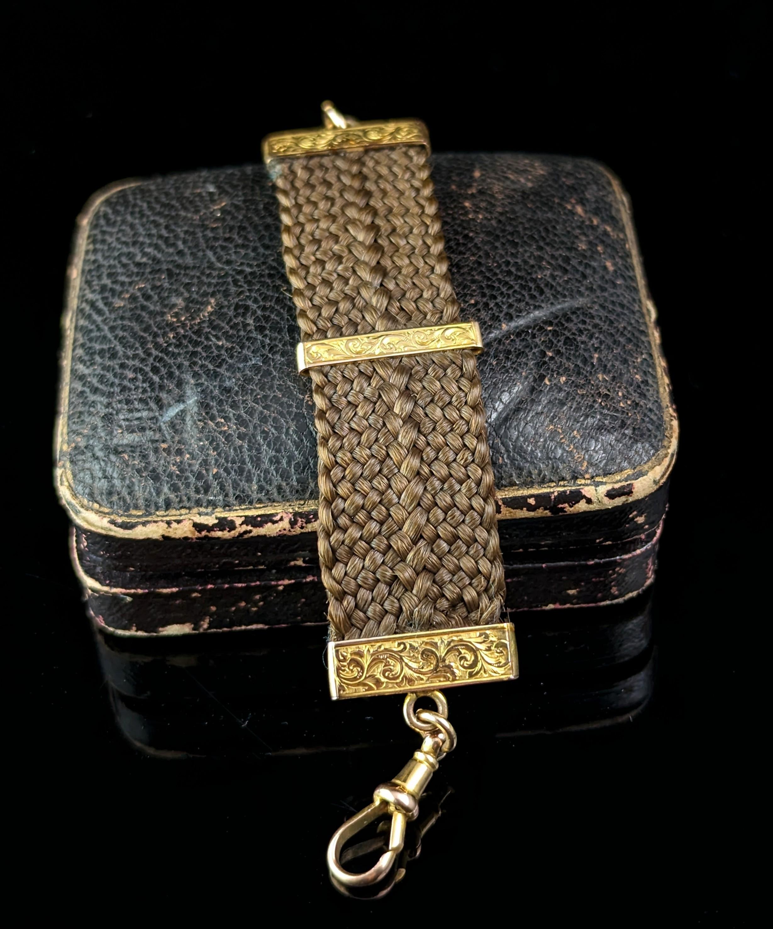 An interesting and sentimental Victorian hairwork watch chain / Fob chain.

Intricately woven mid brown hair with engraved yellow gold end caps and spacer.

It has a dog clip fastening at one end and a spring ring at the other both 9ct yellow gold