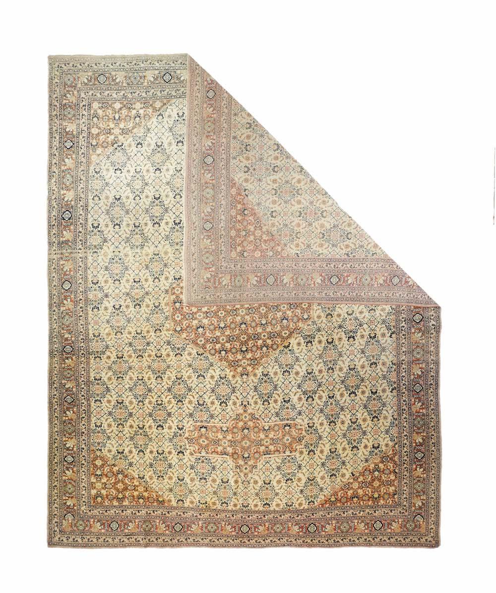 Tappeto antico Haji Jalili Tabriz 8'10'' x 11'5''. Il piccolo e regolare disegno Herati allover del vecchio campo avorio continua inalterato in scala nel medaglione esagonale color ruggine, negli ampi pendenti a cartiglio color ruggine e negli
