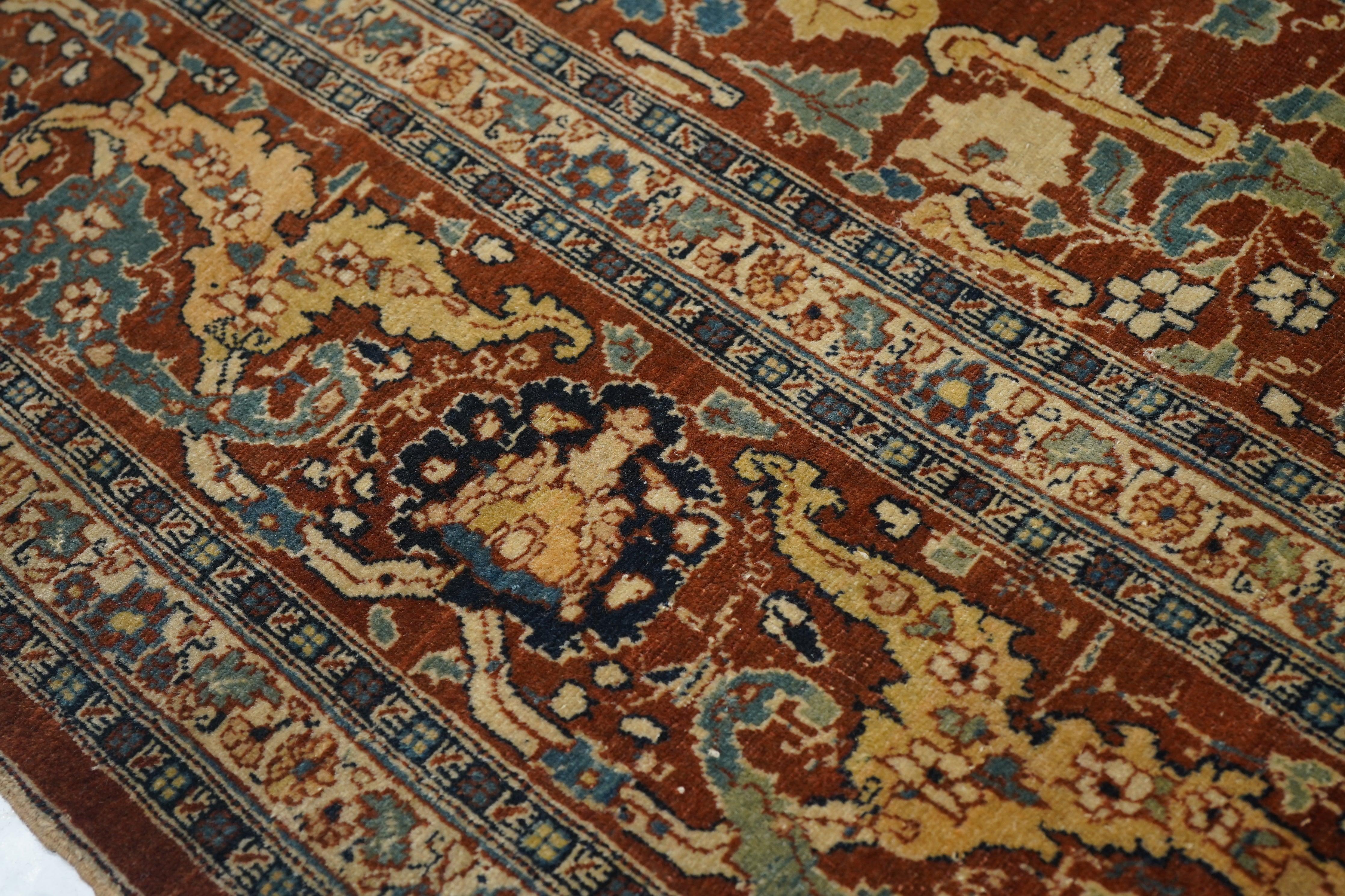 Tappeto antico Haji Jalili Tabriz 8'9'' x 12'0''.  Il fondo beige paglierino, aperto e abraso, mostra un medaglione rosso ellittico a gradini irregolari e spinato con pendenti a palmetta. Congiunta estesa, angoli rossi en suite. Bordo principale in
