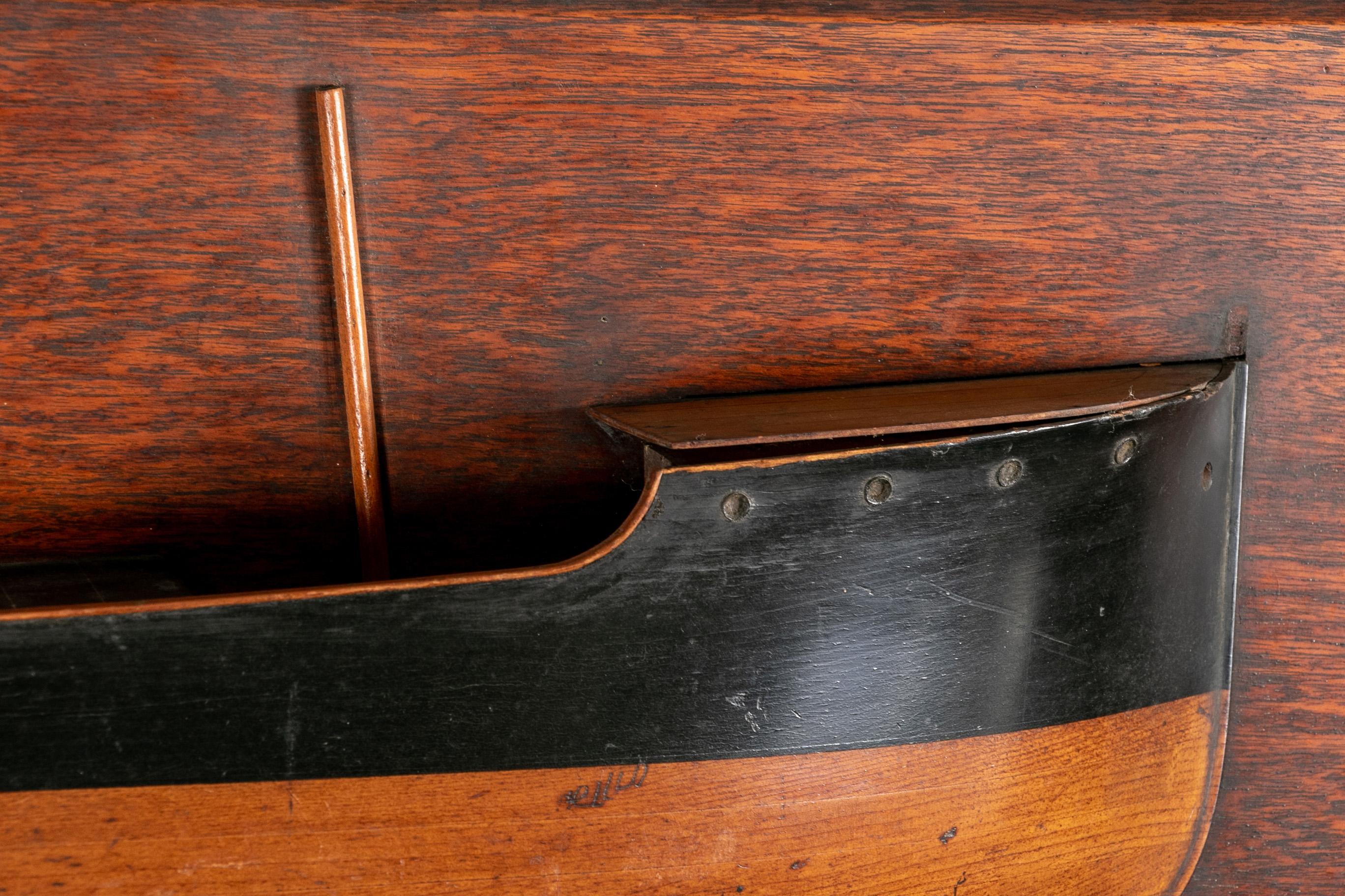 A late 19th century half hull model ship mounted on a 
walnut cradled panel. The hull comprised of half ebonized walnut.
Bears plaque : w. Harkess & Son. Iron and steel ship builders and repairers, MIDDLESBROUGH-ON - TEES

Good condition. Slight