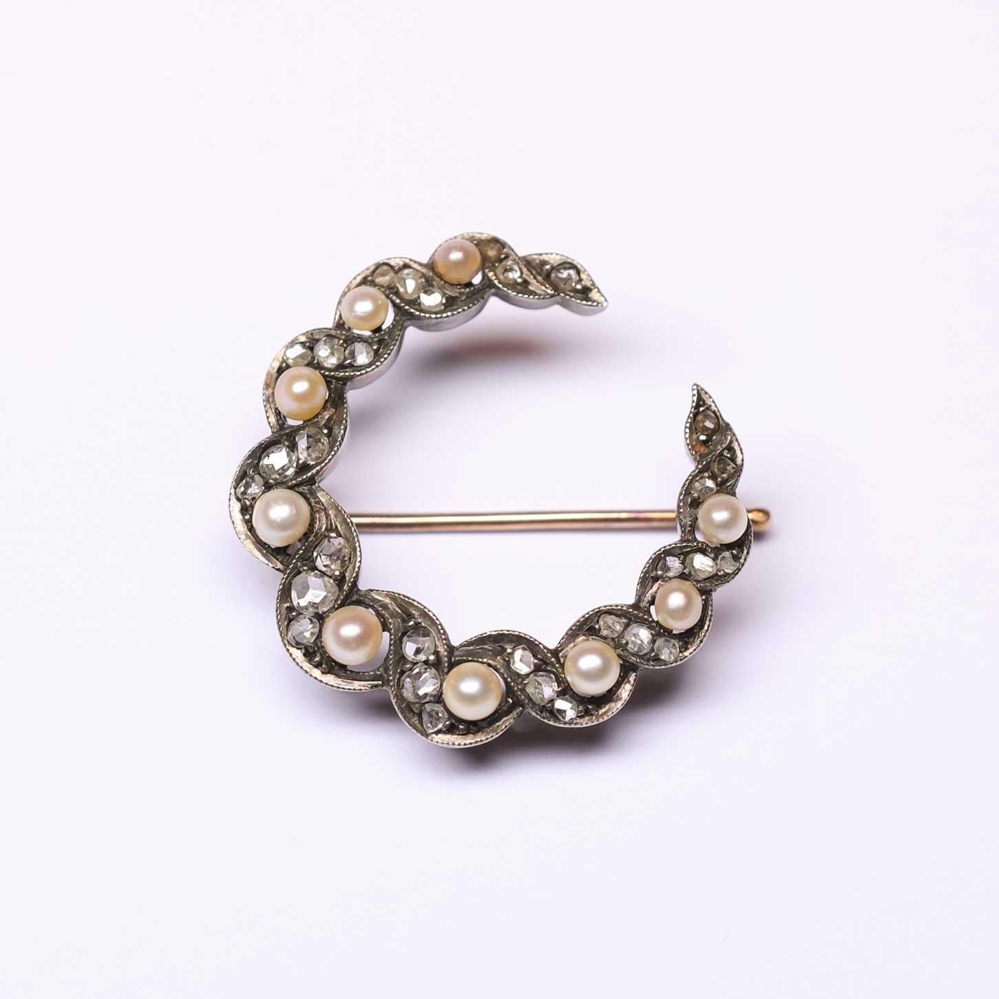 Gorgeous antique half moon crescent brooch. Set in silver and gold with rose cut diamonds and cultured pearls, from the early 1900s circa. In the back there is a small hook which allows for the brooch to be used also as a pendantif.

Highlights
-