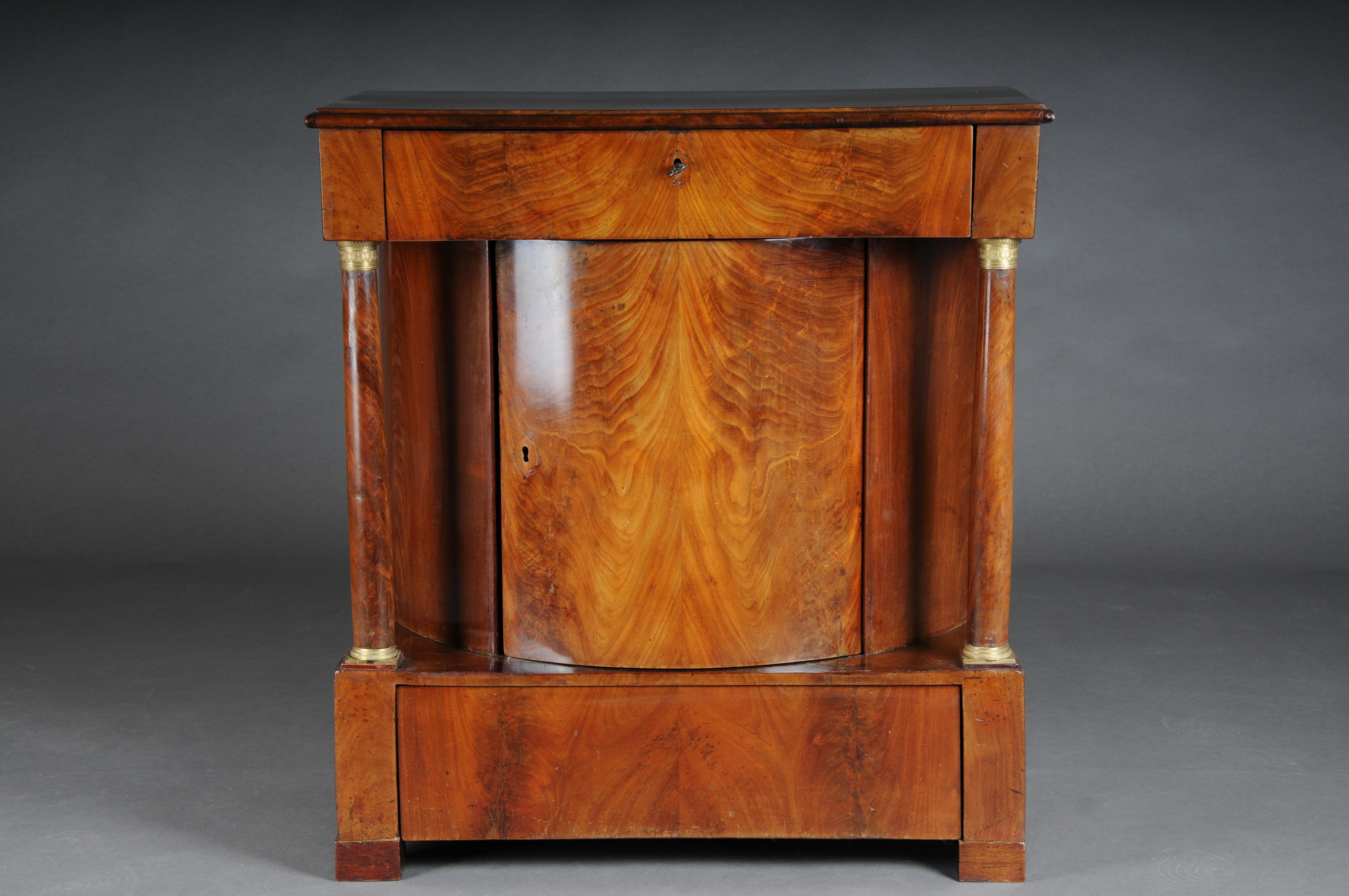 Antique half-round Empire chest of drawers, mahogany, around 1810

Semi-circular body, one door in the middle flanked by full columns and one drawer each above and below. An extremely rare chest of drawers original from the Empire period of