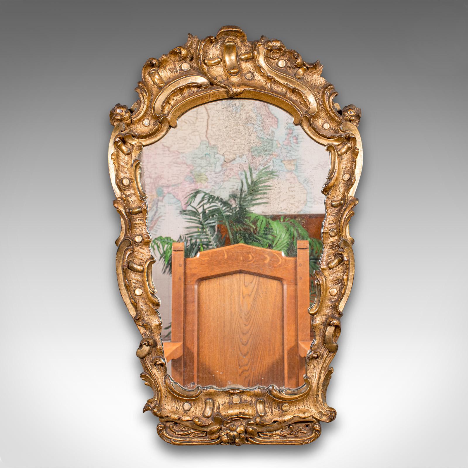 
This is an antique hall mirror. A French, gilt gesso ornate mirror in the Baroque manner, dating to the early Victorian period, circa 1850.

Eye-catching mirror with a superb frame and pleasingly original plate
Displays a desirable aged patina