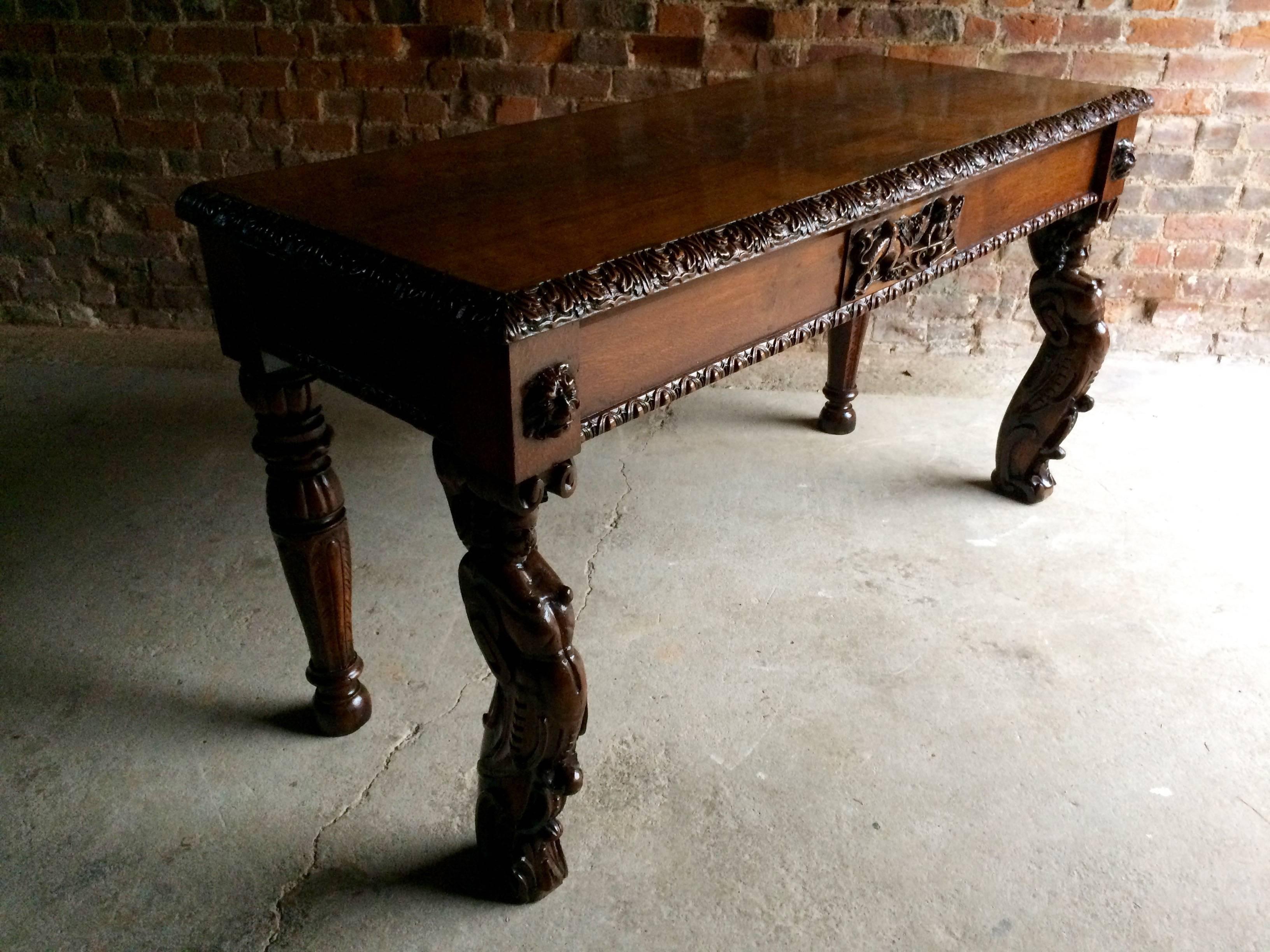A beautiful antique 19th Century profusely carved Victorian Gothic style oak hall table, with a beautiful aged patina, offered in excellent condition. The hall table having rectangular top with carved border and central carving of a cherub, with