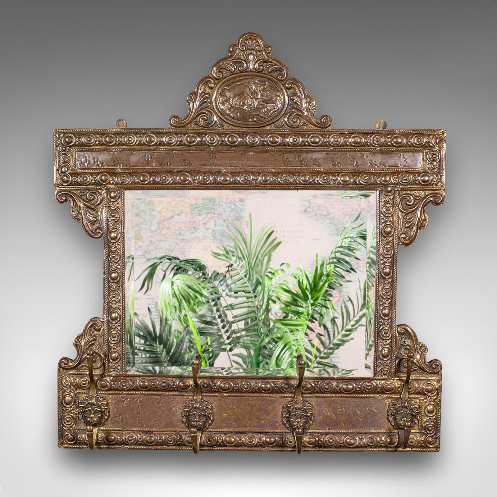 
Il s'agit d'un ancien miroir de valet de couloir. Miroir mural de réception hollandais en laiton pressé, datant de la période édouardienne, vers 1910.

Fascinant exemple hollandais avec une série de crochets utiles pour les manteaux et les