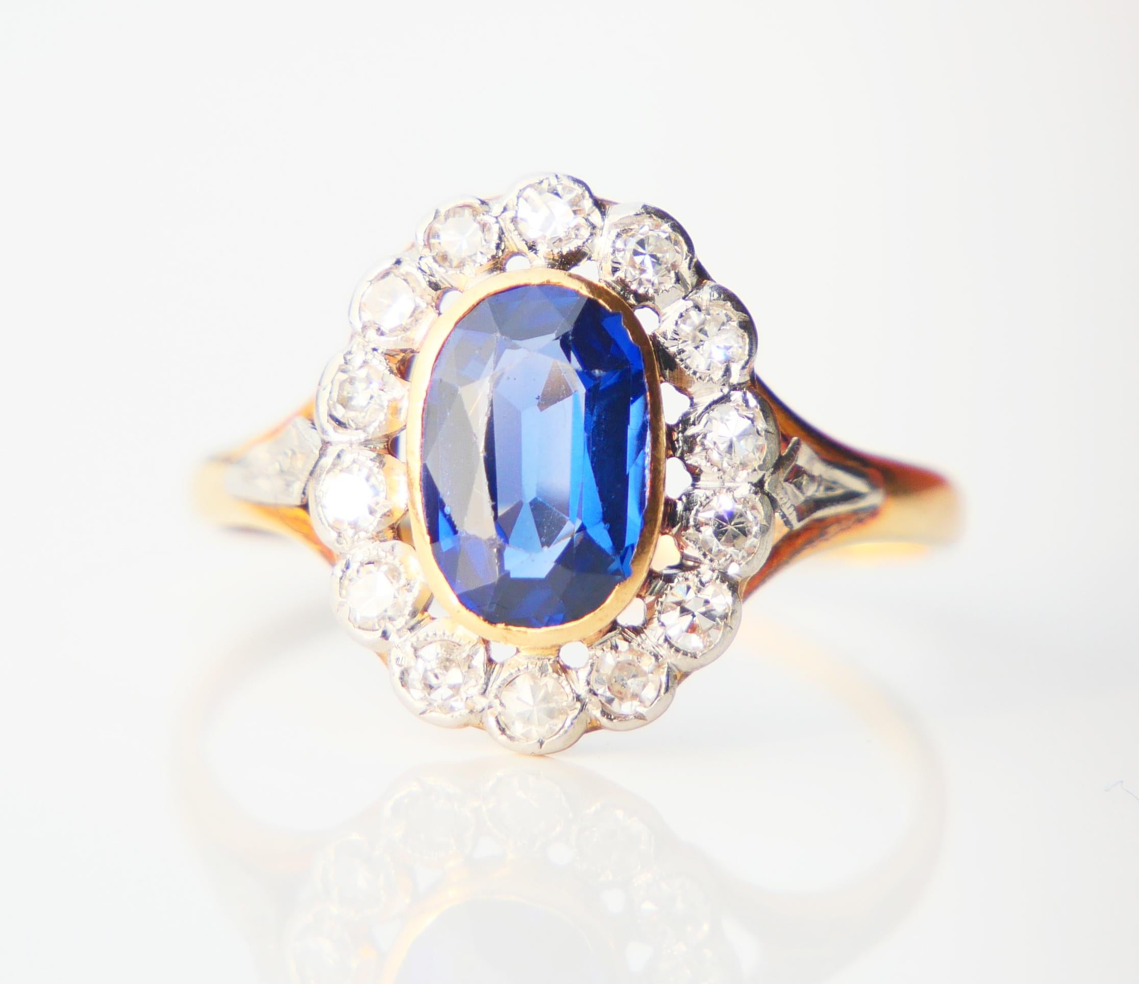 Magnifique bague halo des années 1920-1930 en or jaune 18 carats avec un saphir bleu fait en laboratoire et 14 diamants naturels dans une monture en platine.

Saphir de taille ovale, couleur bleu moyen, mesure : 9 mm mm x 6 mm / ca. 1.85 ct .

14