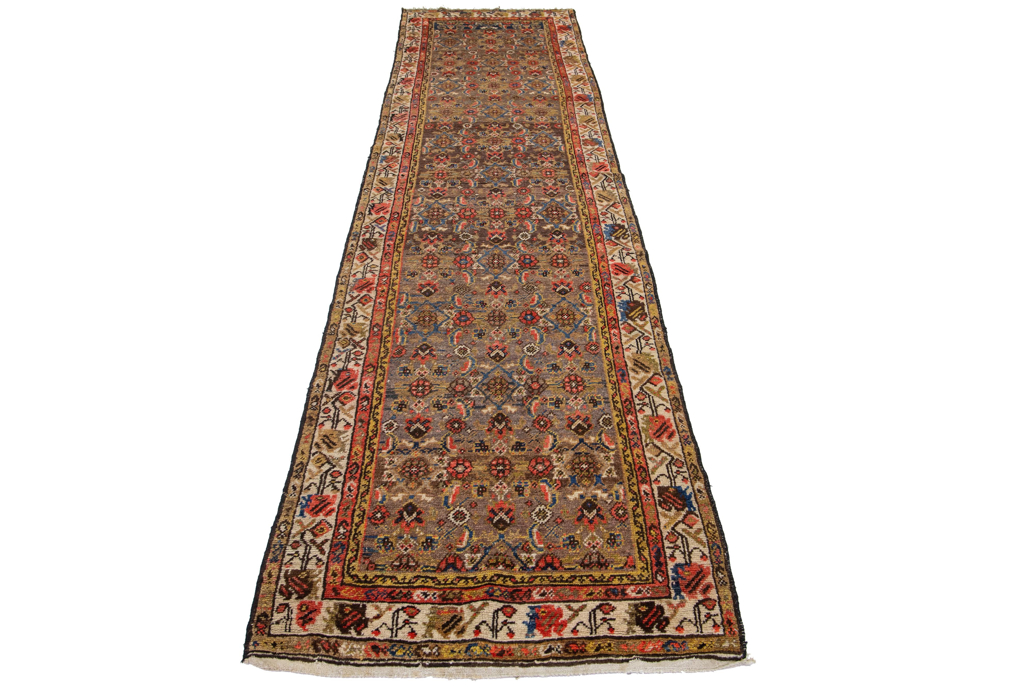 This Antique Hamadan runner is crafted from hand-knotted wool and features a brown field enhanced by a captivating floral design with blue, beige, and rust accents.

This rug measures 3'4