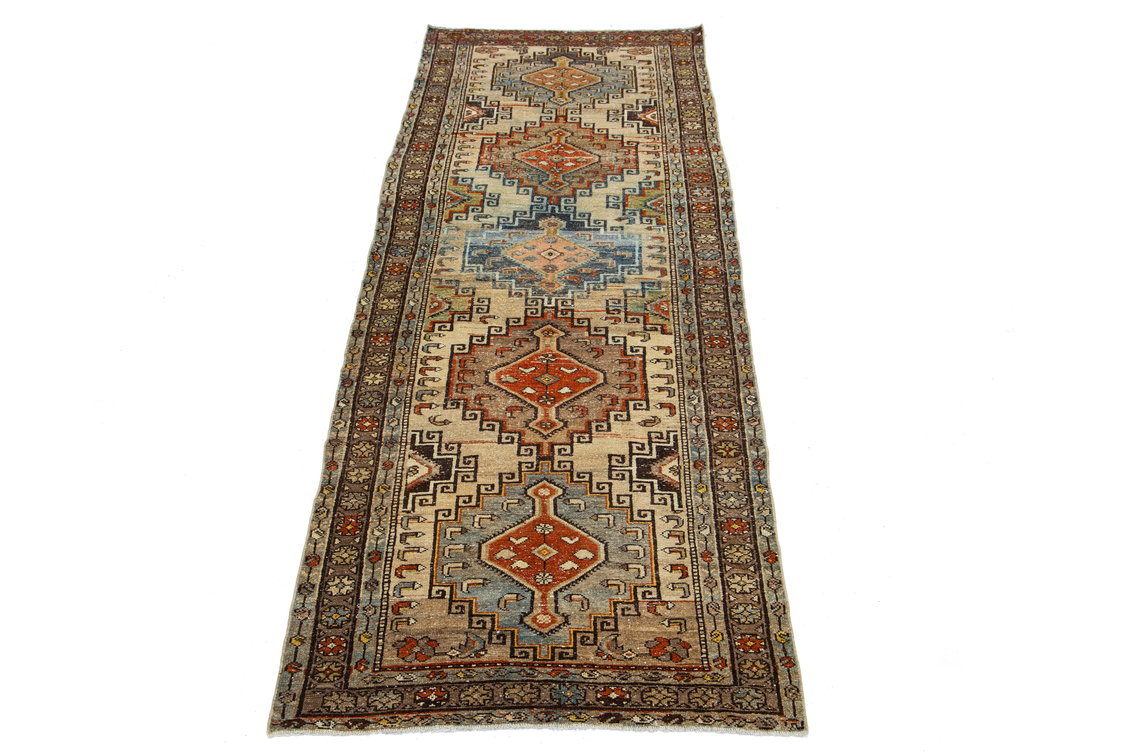 Beautiful antique Persian hand-knotted wool runner with a beige color field. This piece has rust, green, and blue accents in a gorgeous geometric design.

This rug measures 3'3