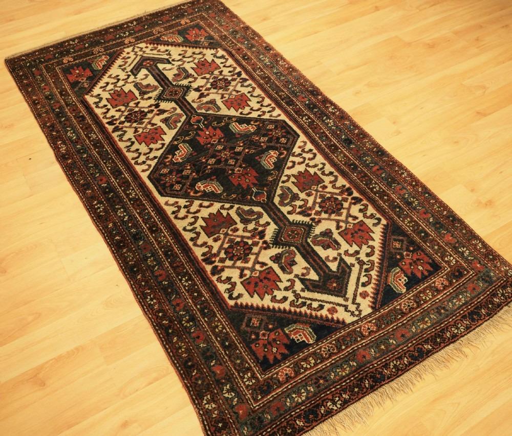 Antique Kurdish Hamadan region village rug of useful narrow size
Circa 1920

The rug has a traditional Kurdish hooked medallion design on a soft ivory coloured ground The rug has a pleasing soft indigo blue border, and has an overall light feel

The
