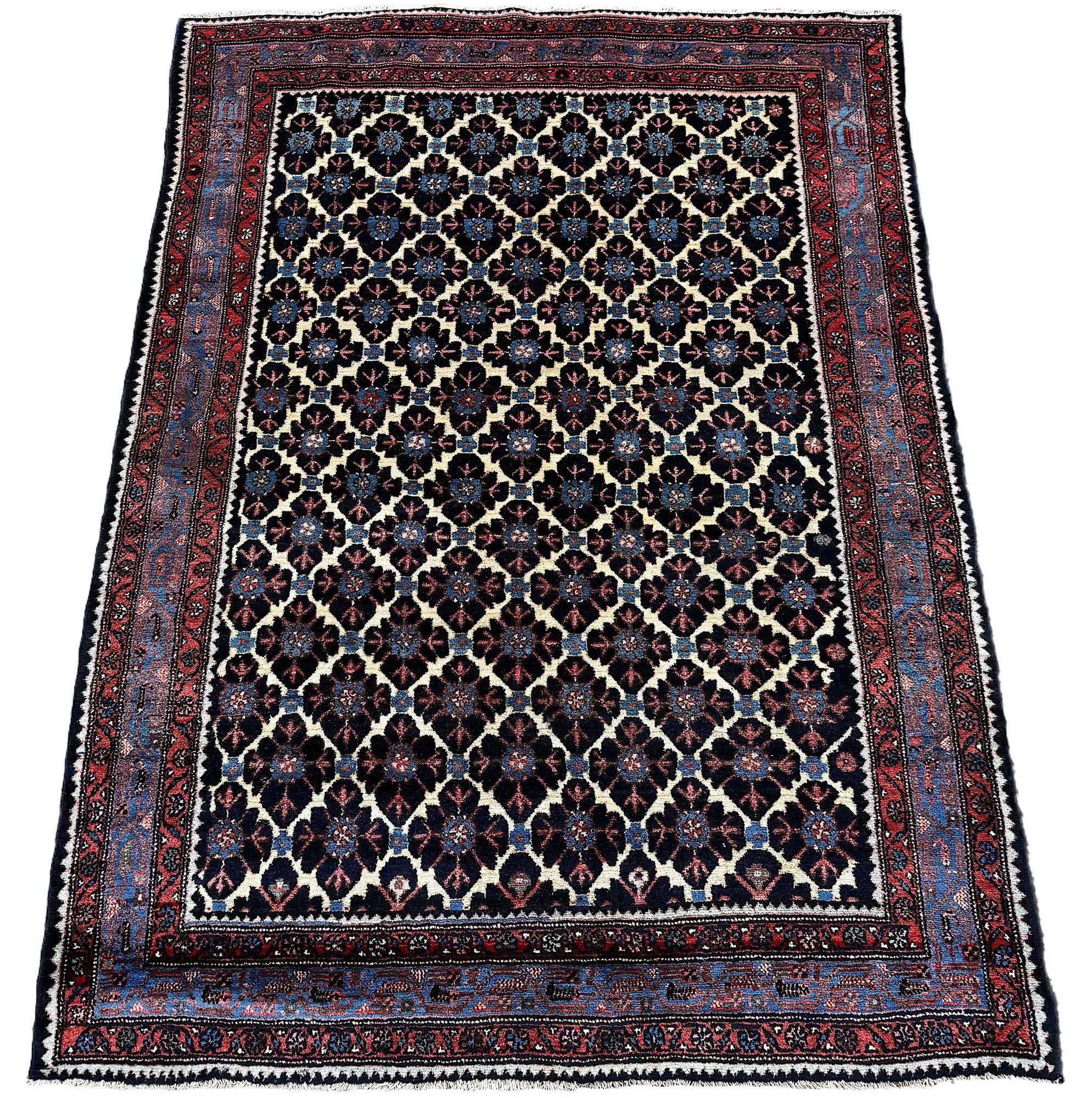 A lovely antique Hamadan rug, woven circa 1920. The rug features an elegant, all over design on an ivory field surrounded by an indigo border and secondary colours of reds and pinks. Lovely quality wool and a great chunky feel
Size: 1.96m x 1.43m