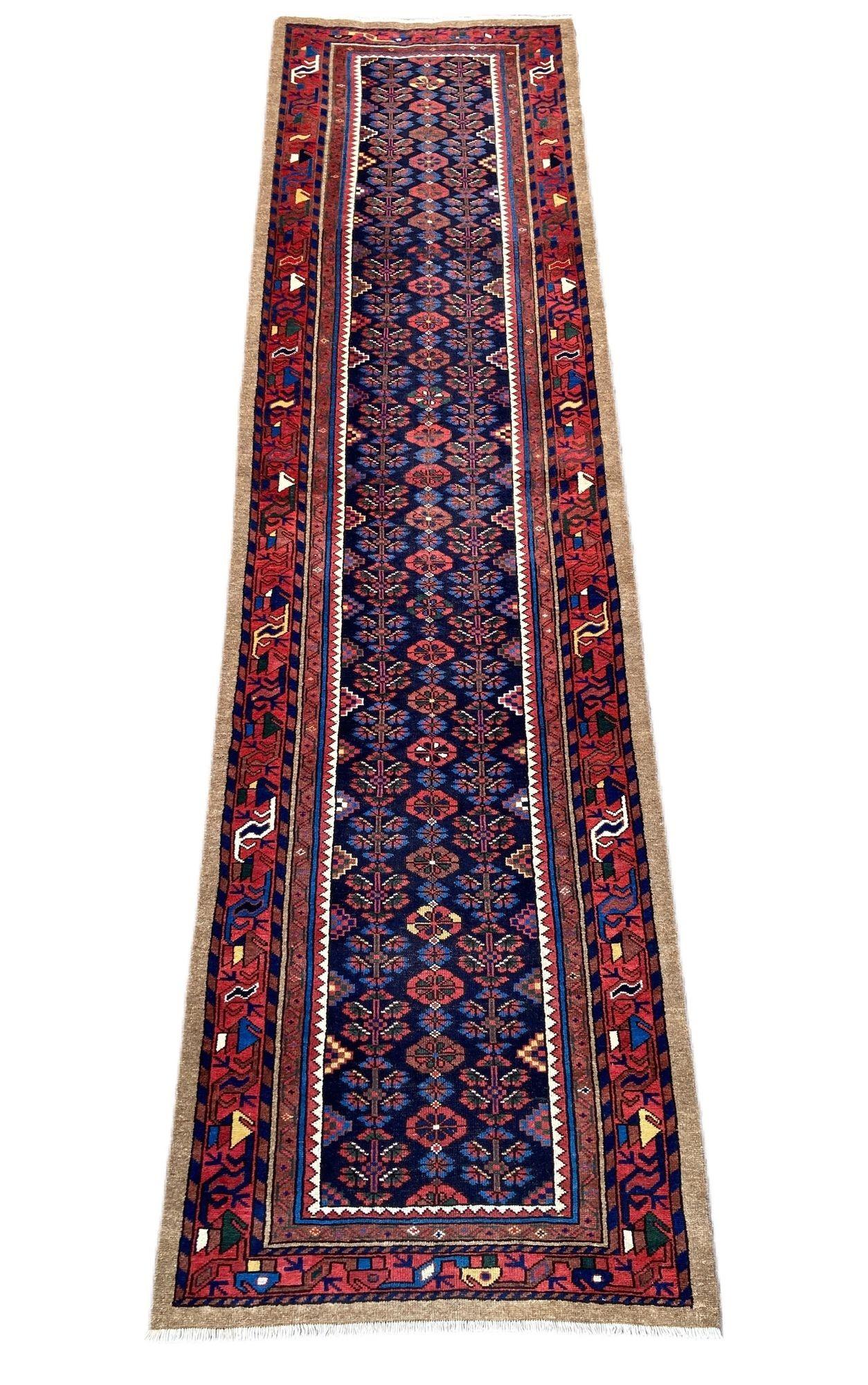 Magnifique chemin de table Hamadan ancien, tissé à la main dans l'ouest de la Perse vers 1910, avec un motif de fleurs stylisées sur un riche champ indigo et une bordure rouge. La qualité de la laine est excellente et les couleurs secondaires sont