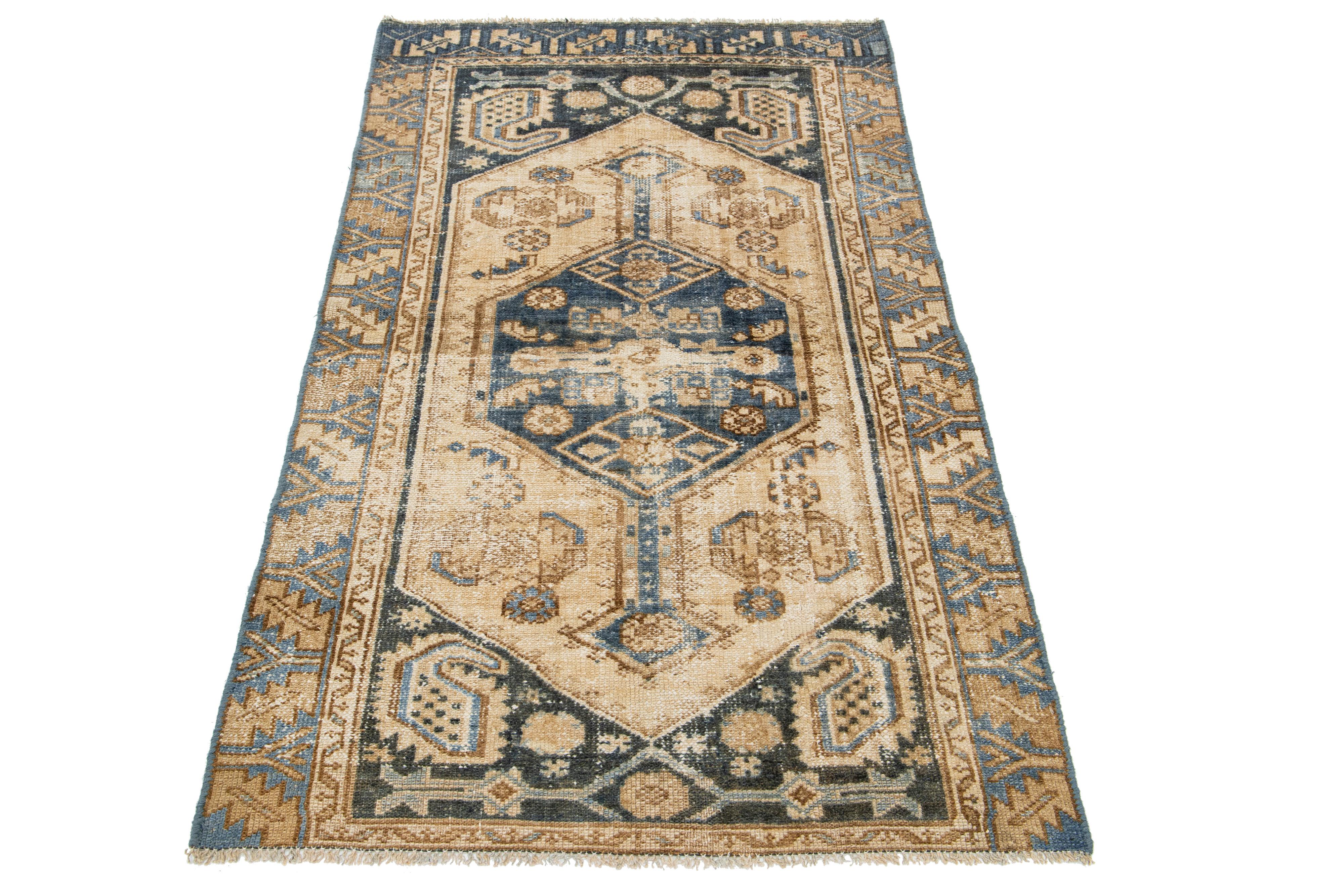 The Antique Hamadan runner is crafted from hand-knotted wool and features a beige field enhanced by a captivating tribal pattern design with blue and brown accents.

This rug measures 3'3