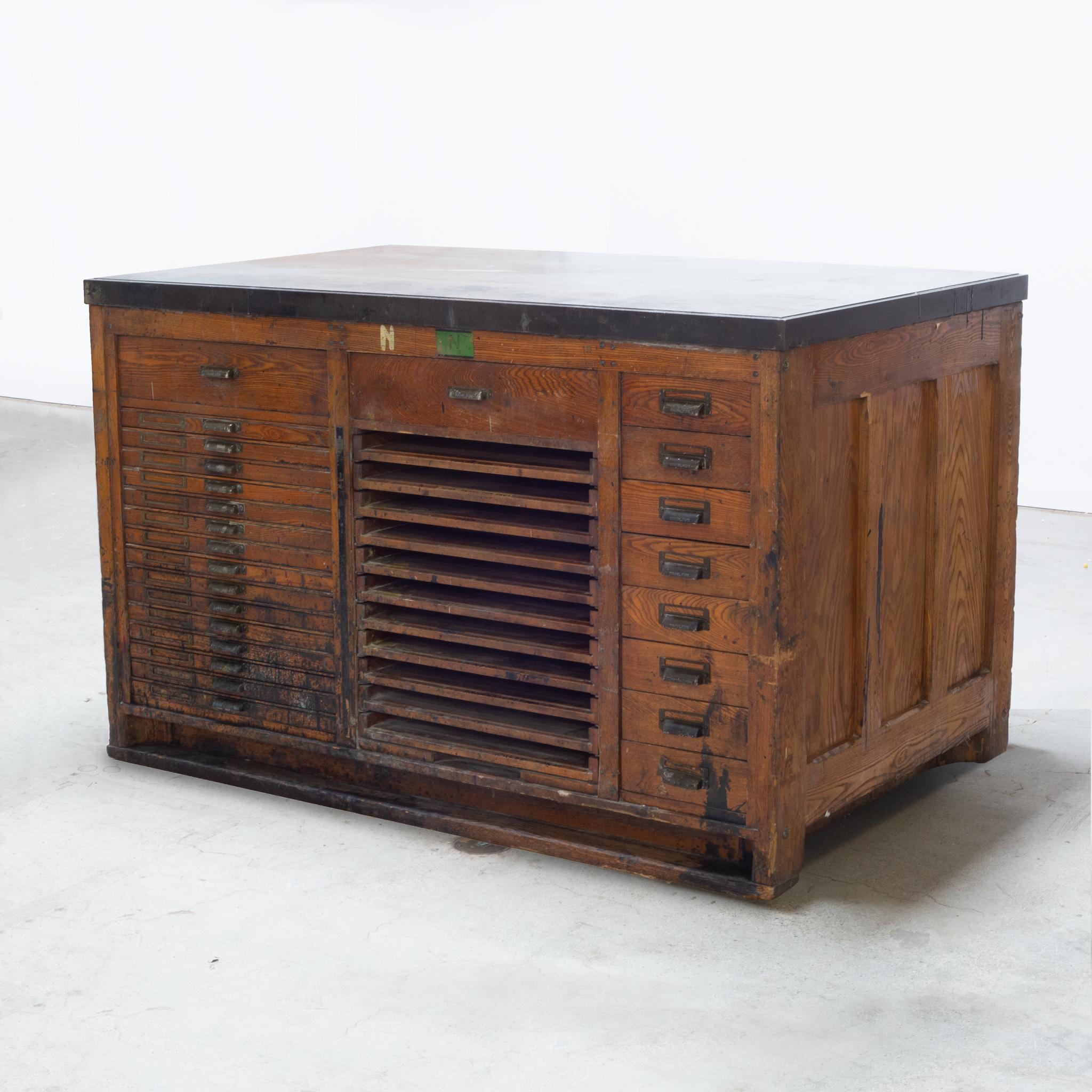 About

An early 20th century printmaker's typeset workbench. The work surface is solid iron and sits on top of the base. The nicely worn wooden base has 2 large drawers, 8 small drawers, 15 flat drawers with brass cardholders, and 11 pull out
