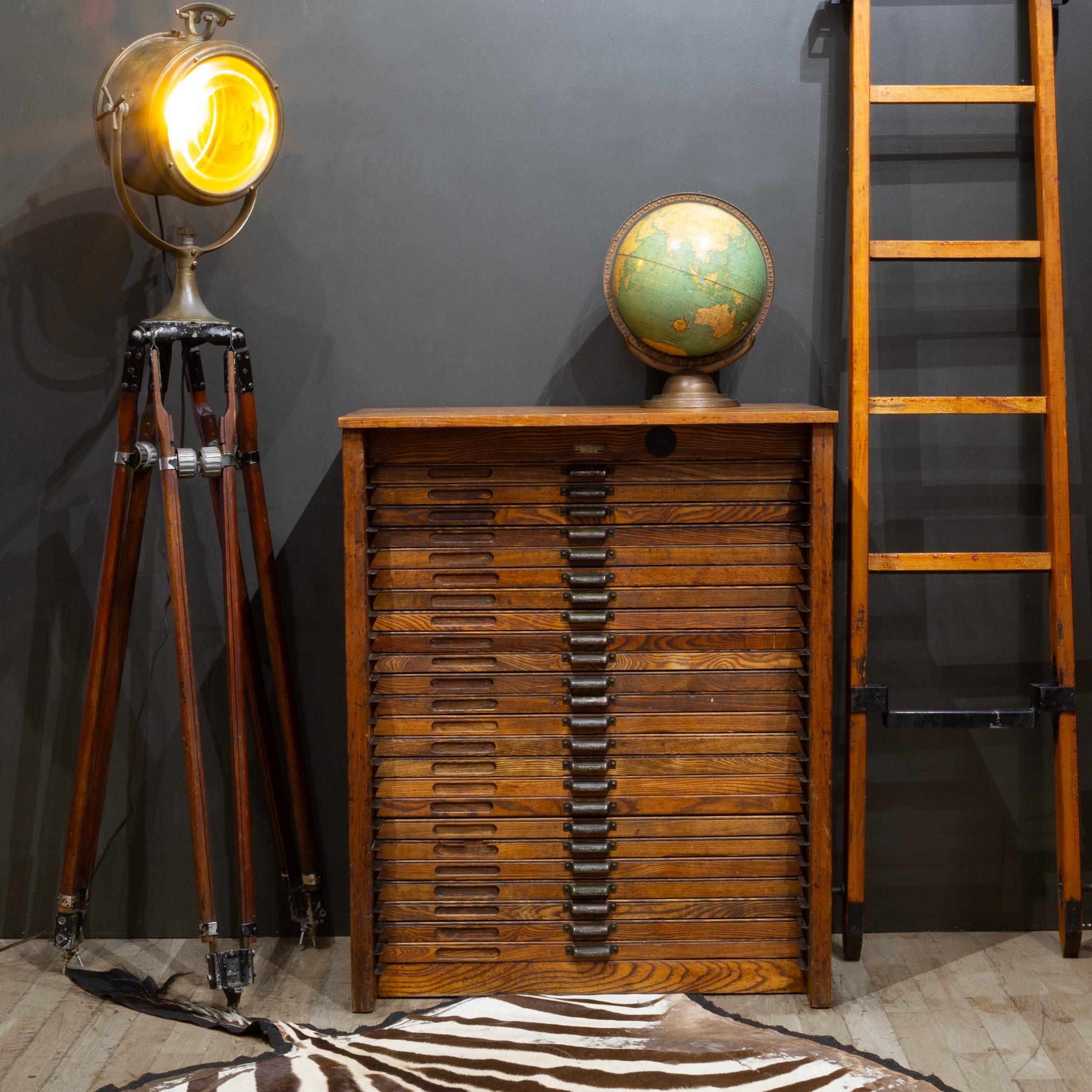ÜBER

An early 20th century printer's wooden cabinet by Hamilton Mfg Company with 24 segmented wooden drawers on steel rails used to house steel typeset letters. Three drawers have the segments removed. Each drawer has label cutouts and army green