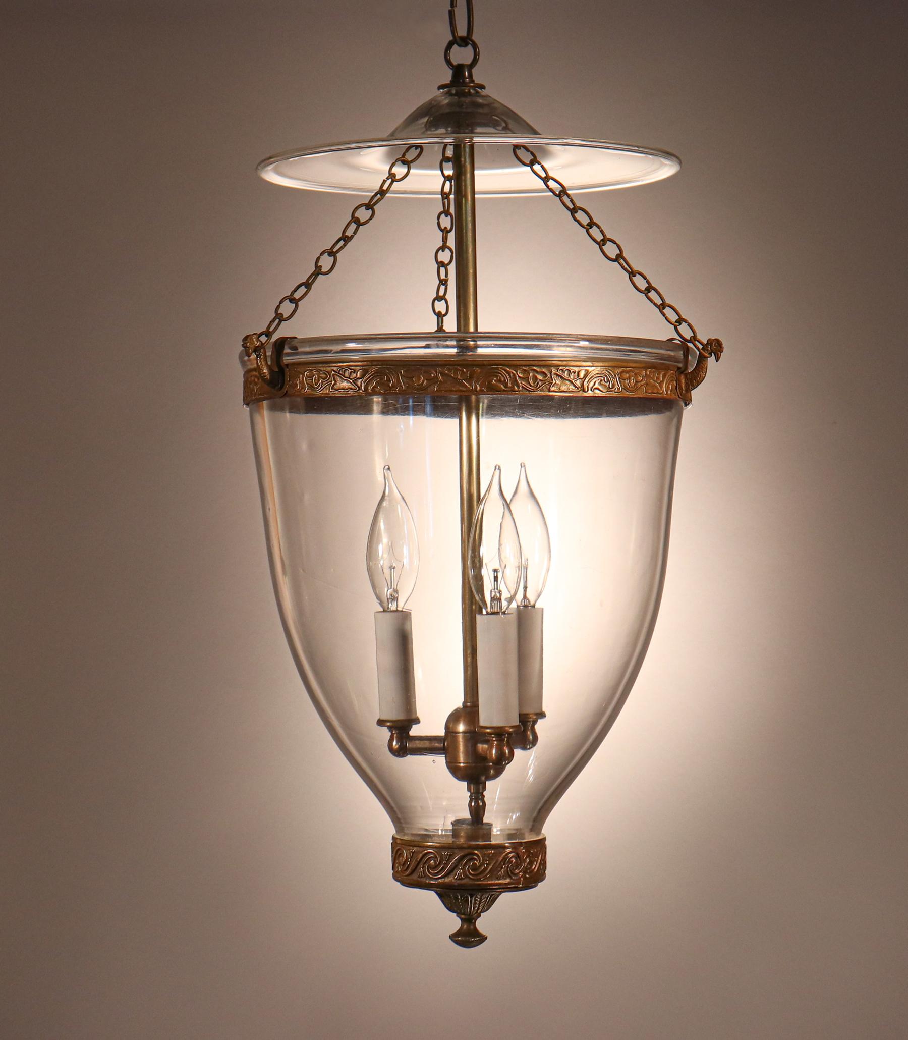 An outstanding lantern in our extensive bell jar collection, this circa 1860 English pendant features superb quality hand blown glass replete with desirable swirls and several air bubbles. The lantern's statement brass finial or candleholder base