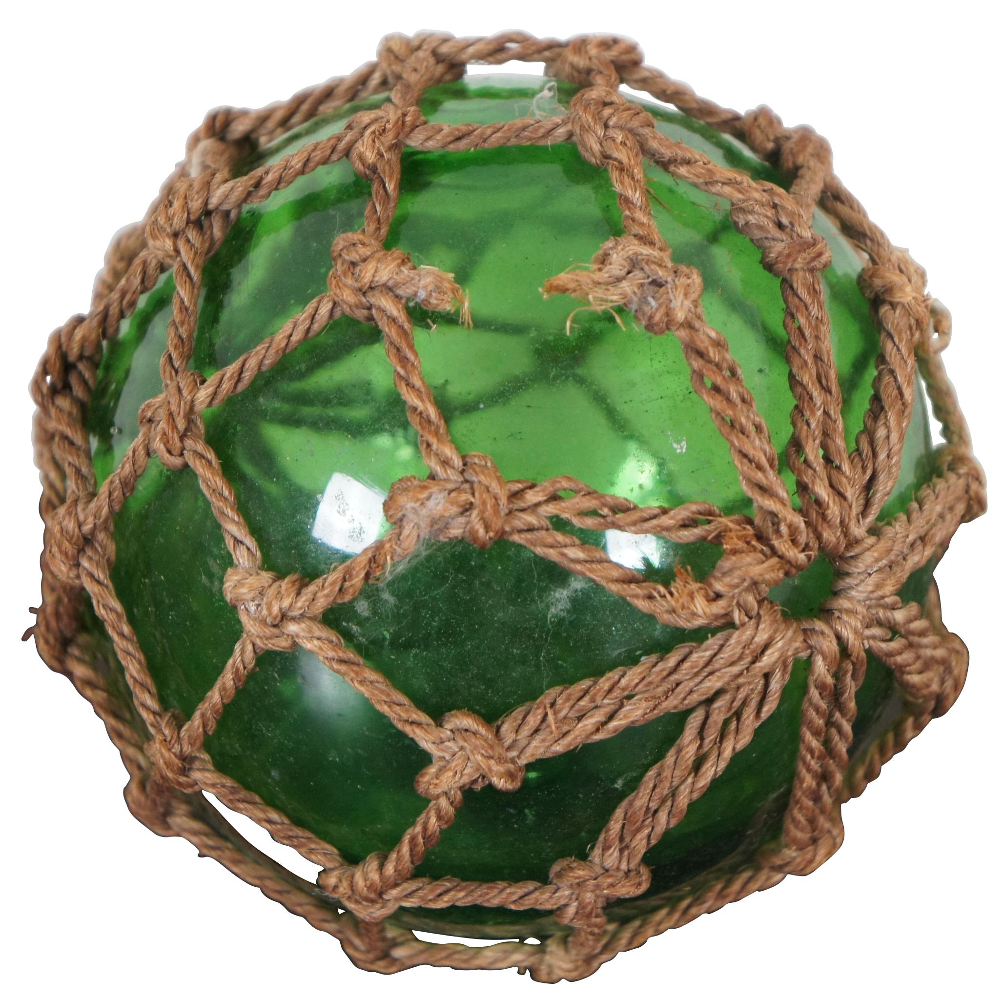 Net wrapped hand blown green glass Japanese fishing float.
  