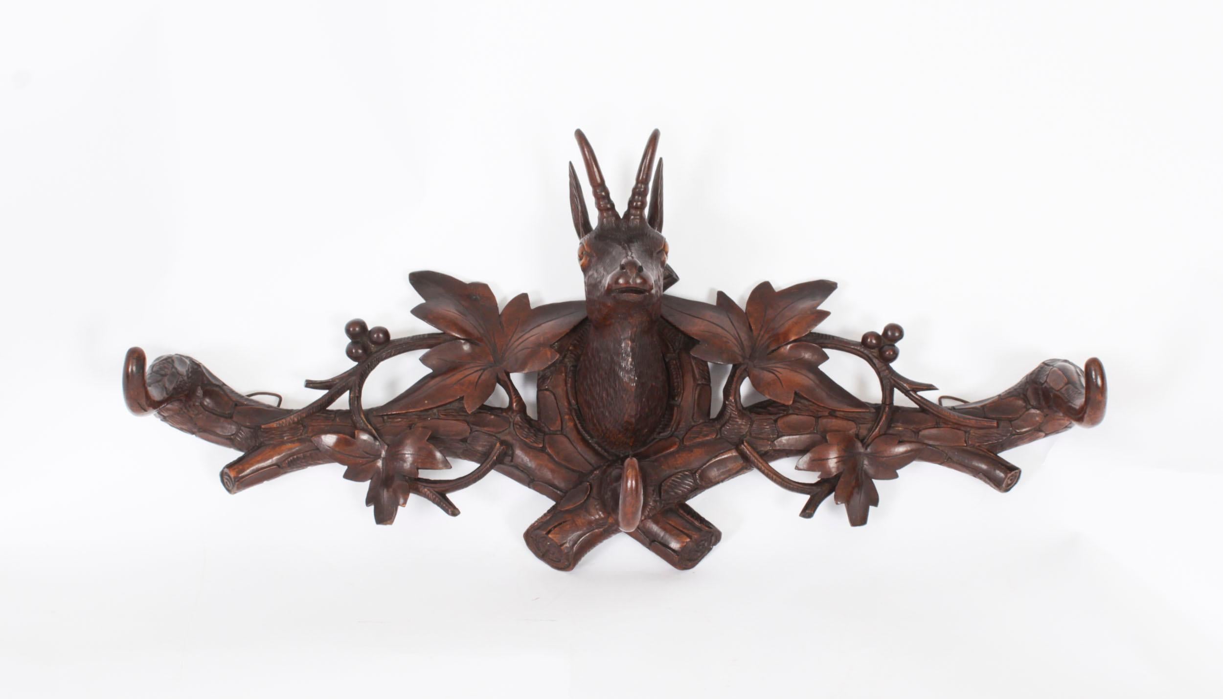 This is a stunning and rare Black Forest wall mounted carved deer's head hat and coat rack with glass eyes and with branch and leaf decoration, Circa 1880 in date.

This gorgeous antique was painstakingly hand-carved from Black Forest linden