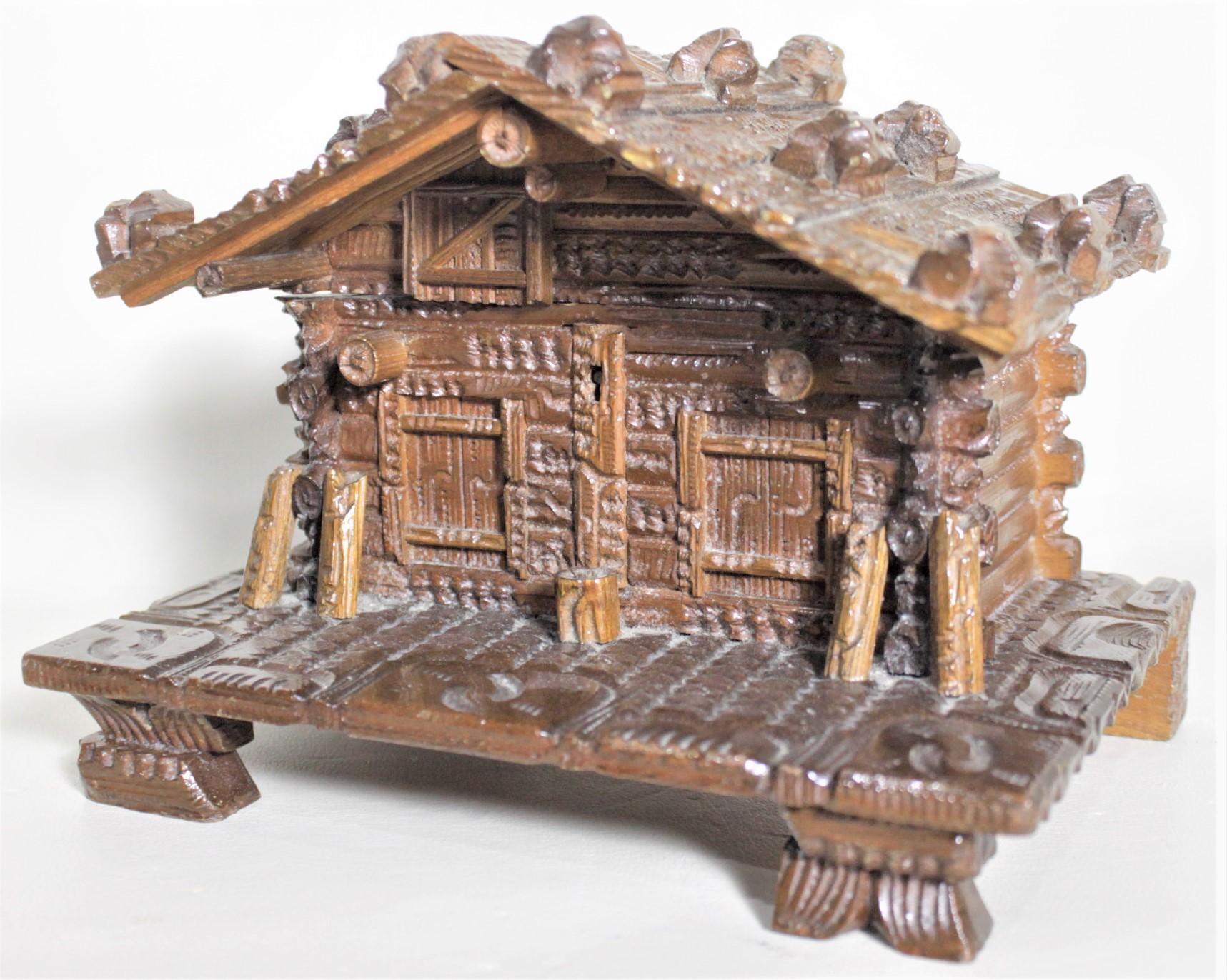 This antique hand carved Black Forest jewelry or trinket box is unsigned but presumed to have been made in either Germany or Switzerland in circa 1920 in the signature Black Forest style. The box an ornately carved log cabin done with great detail,