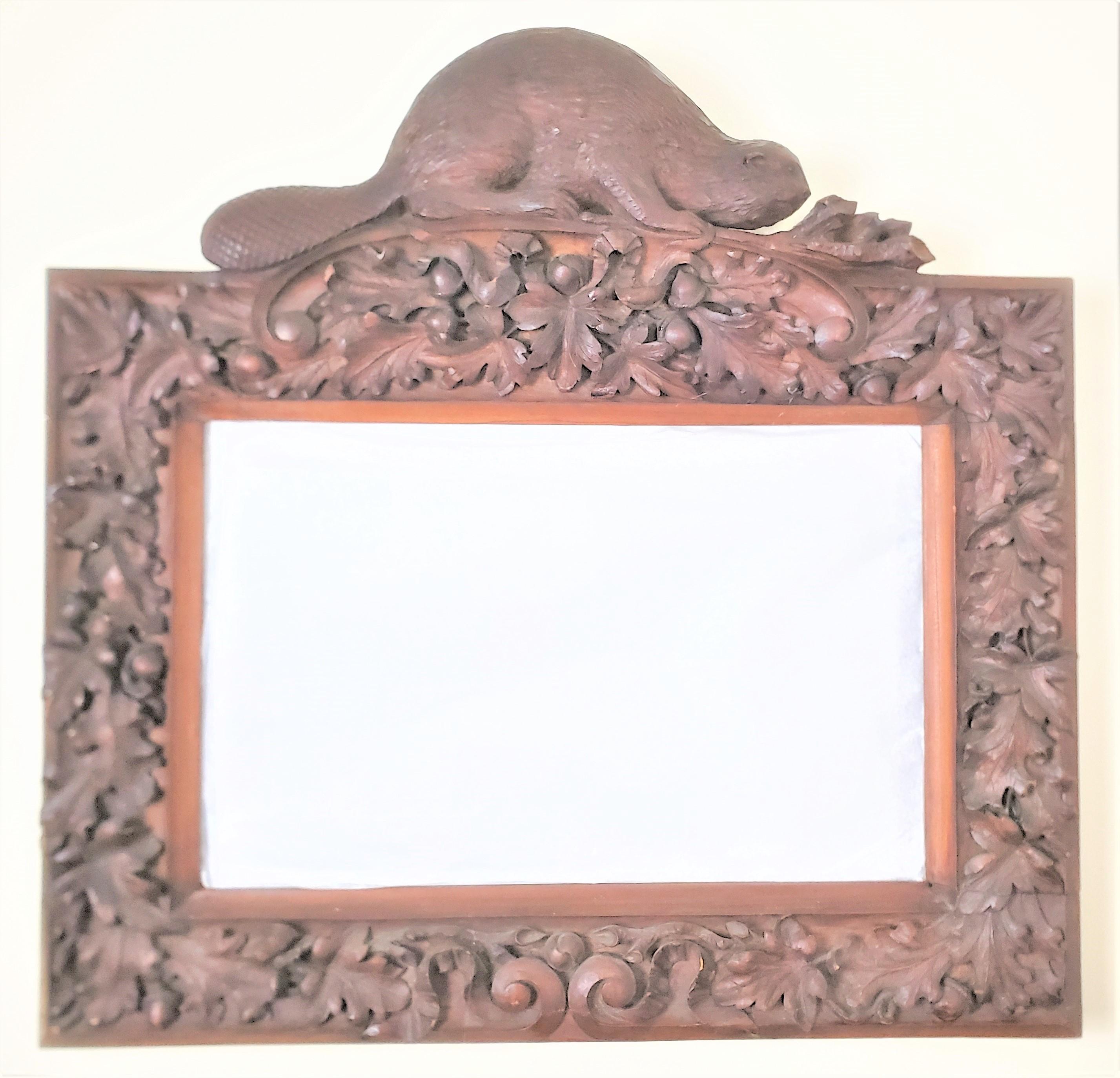 This antique hand-carved frame is unsigned, but originated from Canada and dates to approximately 1880 and done in the period Folk Art style. The frame is composed of solid walnut and features a large sculpted beaver at the top sitting on a branch.