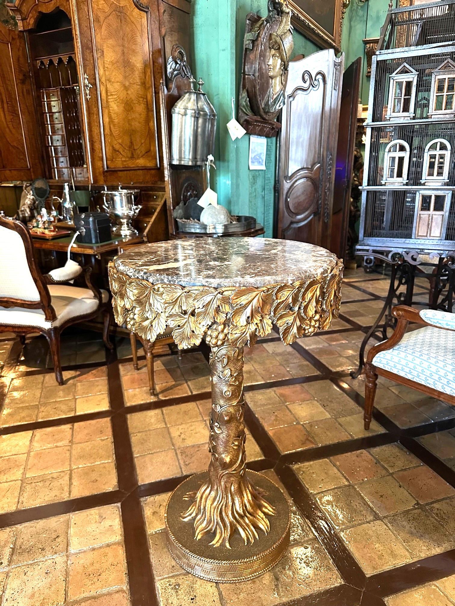 Table d'appoint en bois sculpté et doré et plateau rond en marbre Charmant et rare piédestal en bois sculpté et peint à la main sur un socle Sculptural en forme de racines et de feuilles d'arbre, cette œuvre incroyable présente un design élégamment
