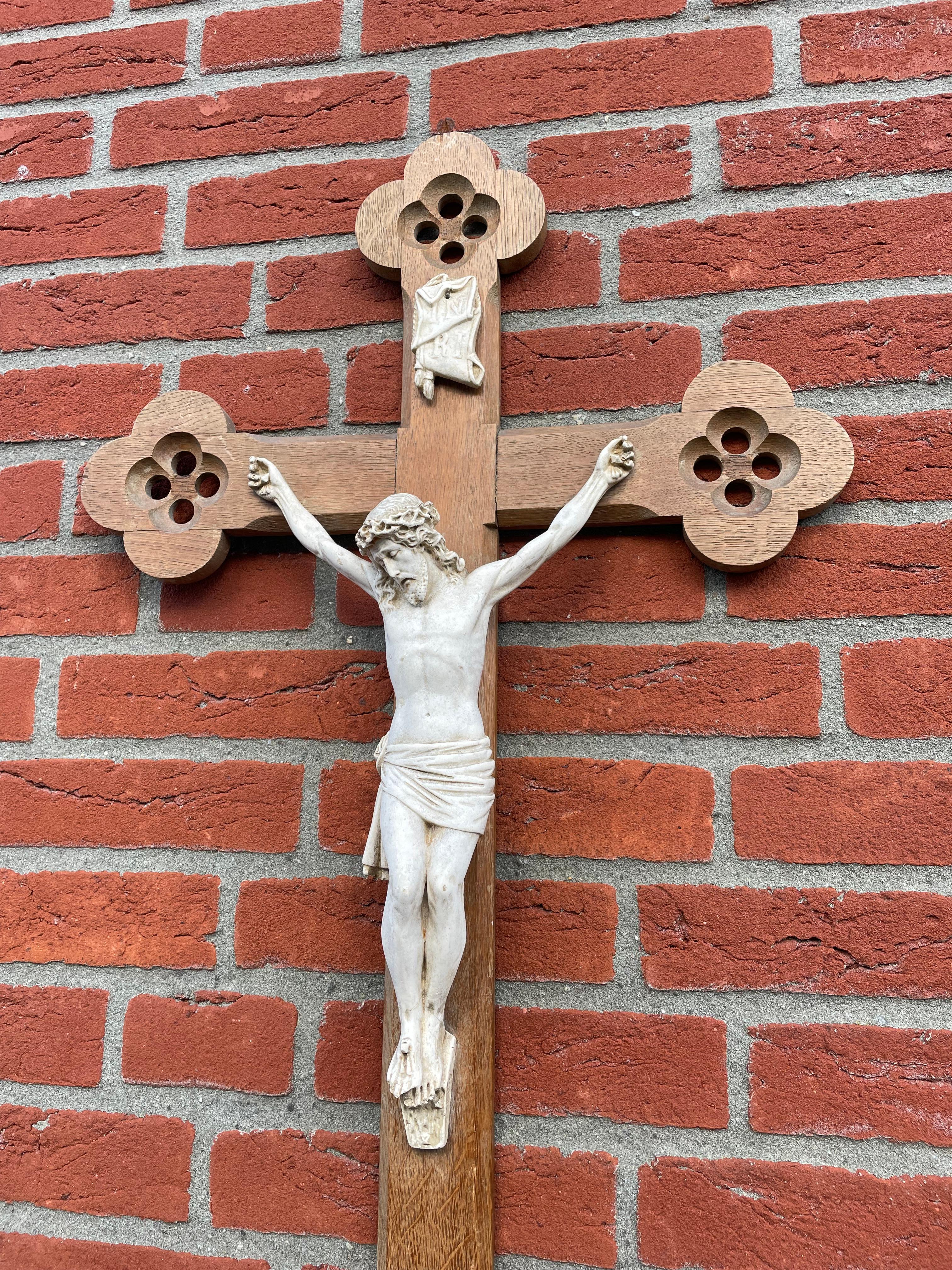 Crucifix d'église de style gothique avec un corps du Christ en argile magnifiquement détaillé.

Les éléments gothiques quadrilobés, sculptés à la main à toutes les extrémités de la croix, confèrent à cet élégant crucifix un caractère tout à fait