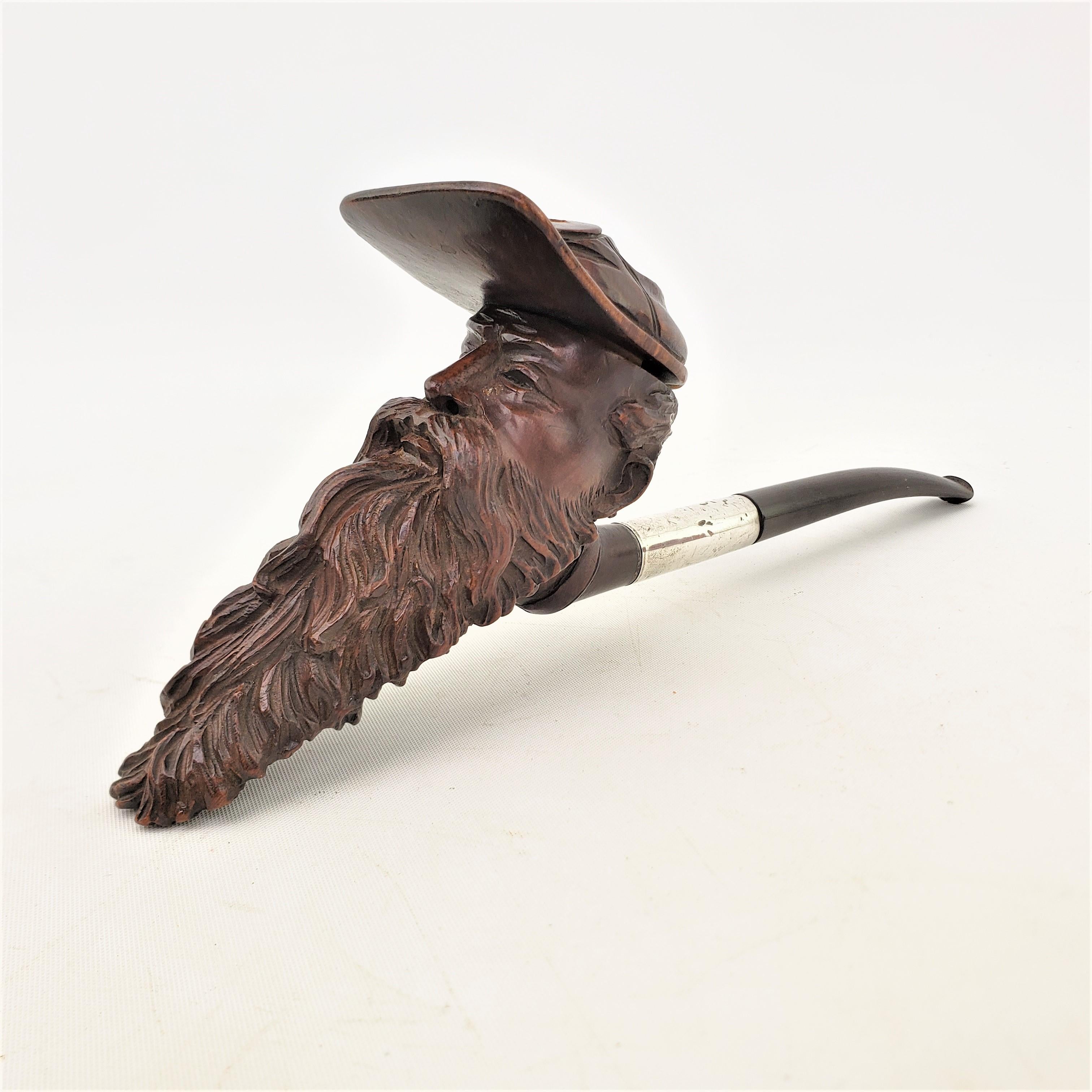 This very well executed hand-carved smoking pipe is unsigned, but presumed to have originated from the United States and date to approximately 1920 and done in an American Craftsman style. The pipe stem is composed of vulcanite with a silver plated