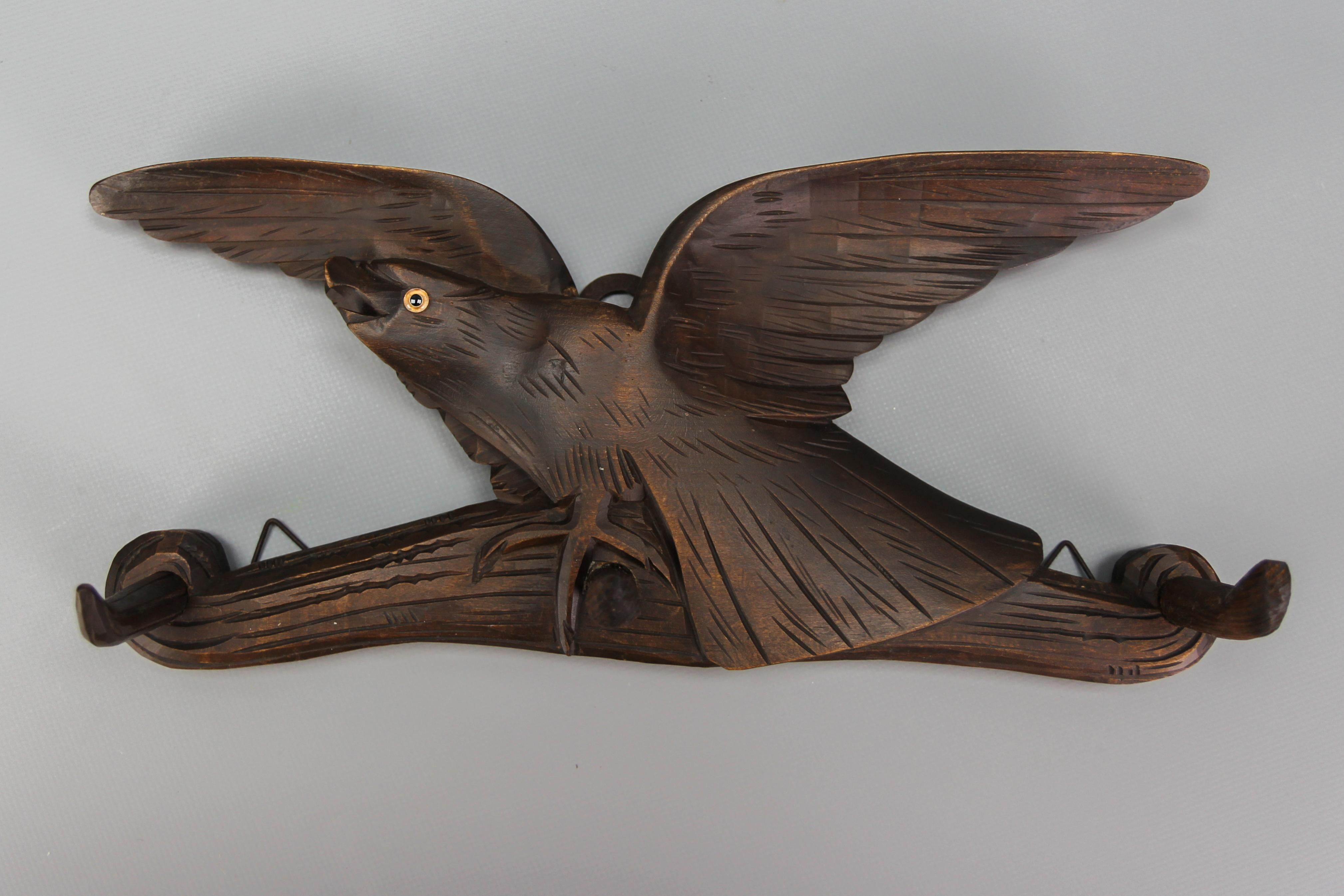 Antique hand-carved hat rack or coat rack with a bird and three wooden hooks
This beautiful, dark brown hand carved wall mount hat rack features three wooden hooks and an expressive hand carved figure of a bird sitting on a branch. Made of linden