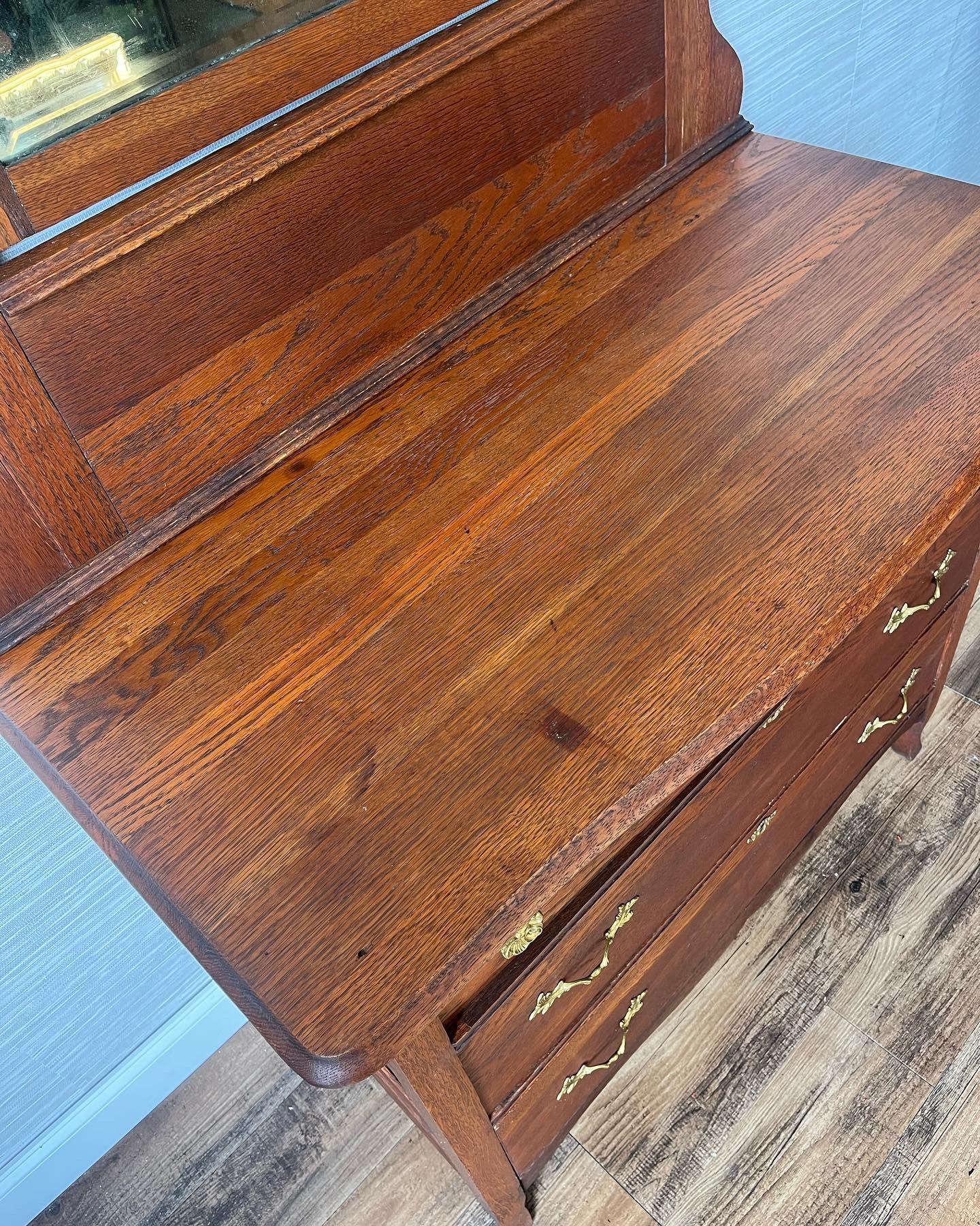 Unveil the timeless elegance of the early 1900s with this splendid Eastlake-style dresser, meticulously crafted from quarter sawn oak. Revered for its strength and the enchanting tiger-eye patterns in the grain, this technique underscores the wood’s