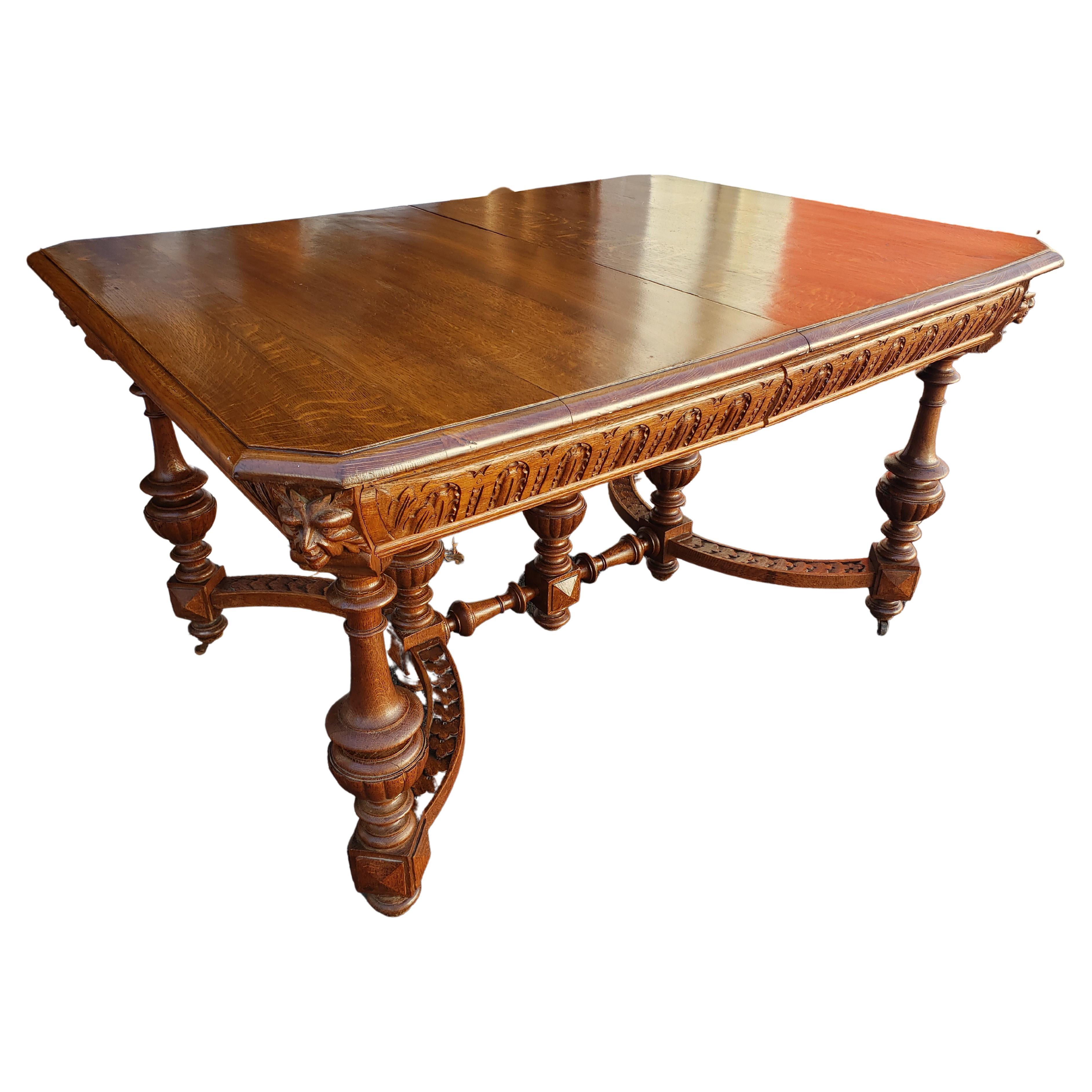Gorgeous Hand carved oak Jacobean style dining table. Use as a library/office table or desk. Beautiful oak top with substantial hand carved legs and stretchers on original casters. Perfect for an English Tudor, French Country, Craftsman or cottage