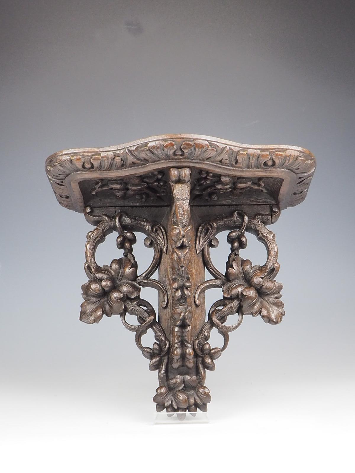 Antique Hand Carved Oak Wall Mounted Shelf, a true testament to the timeless beauty of English oak craftsmanship. This exquisite piece showcases an impressive level of detail, with intricate carvings of vine leaves that add a touch of elegance and