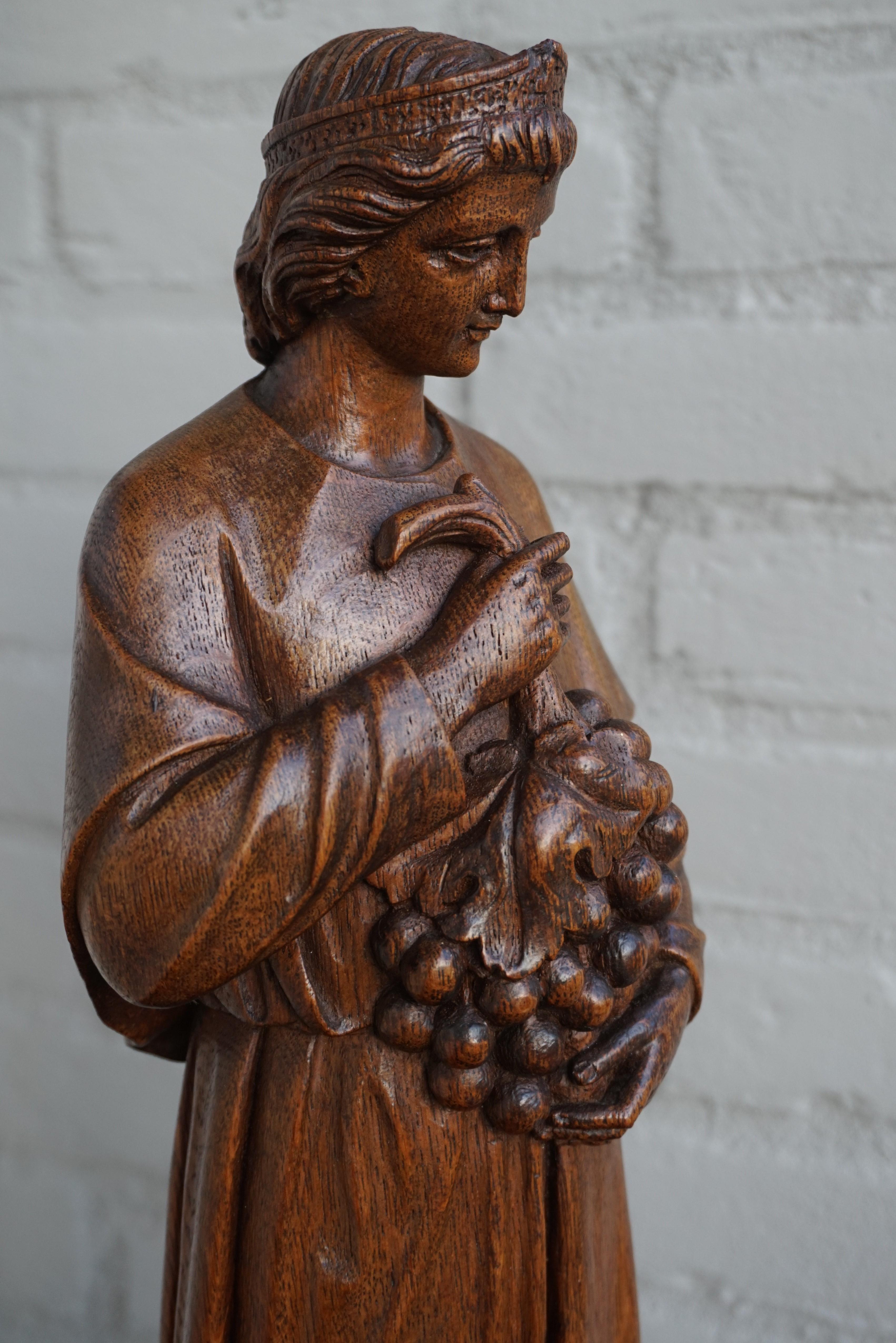 Wonderful church relic with a beautiful patina.

Over the years we have sold various hand carved wooden sculptures of saints, but we have never seen this particular saint holding a large grape bunch. Unfortunately we don't know who he or she is.