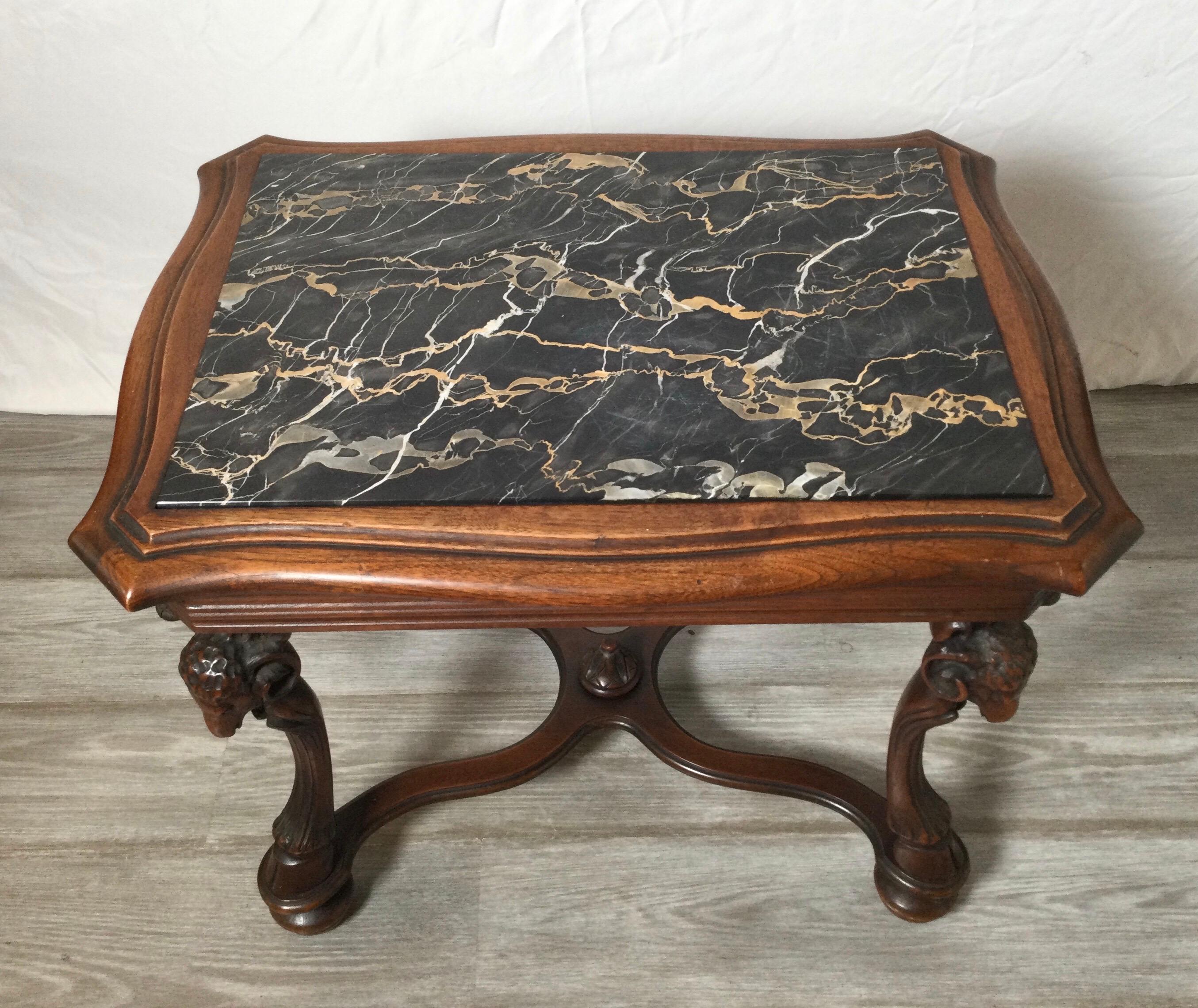 Aesthetic movement hand carved walnut and marble table. The table with beautifully carved ram head and hoof at the feet with a black marble top insert.