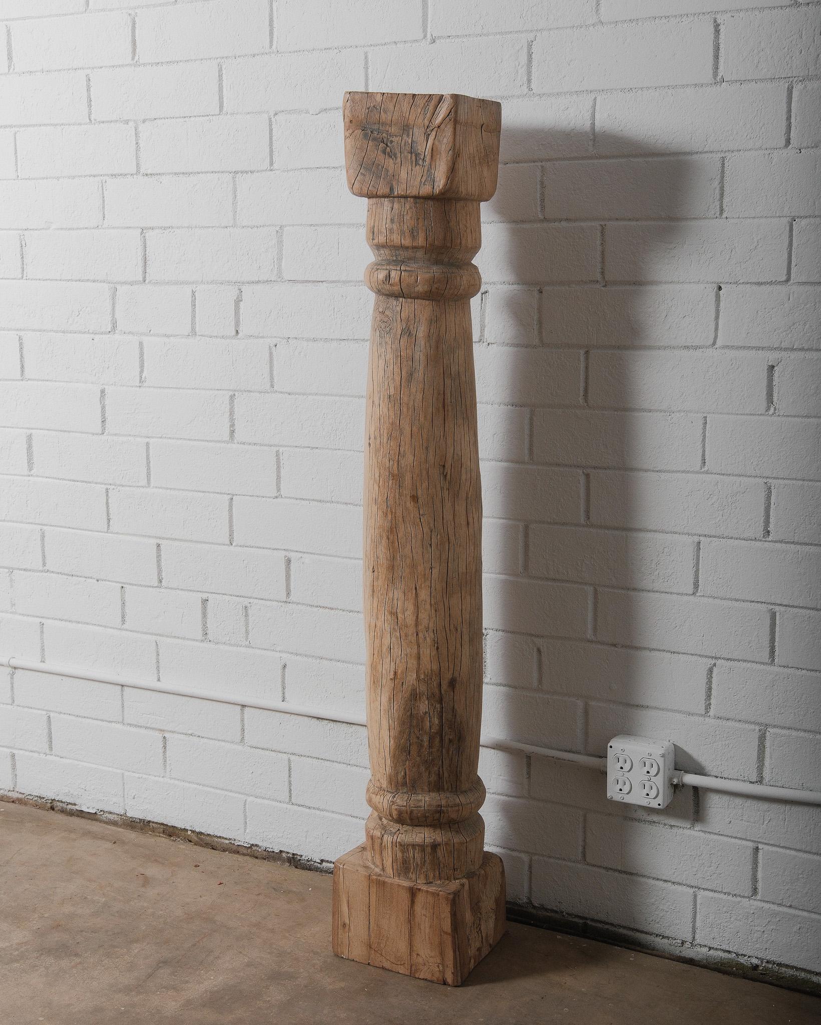 This antique hand-carved teak wood column is a stunning architectural piece, exuding rustic charm and timeless character. Crafted from solid teak wood, the column showcases a beautifully weathered patina, with natural cracks, grain variations, and a