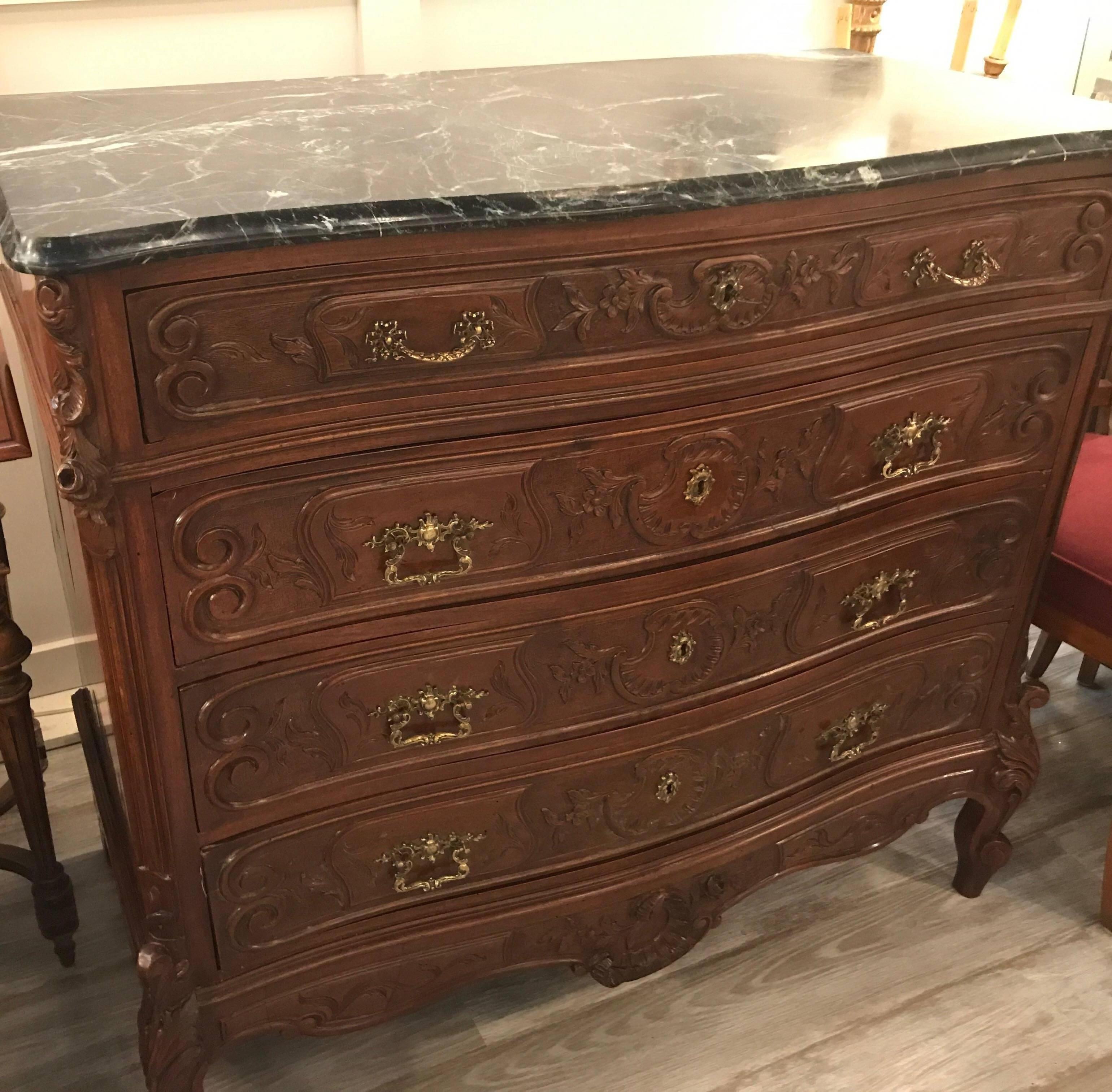 Beautiful hand carved French walnut console with marble top. Hand carved drawer fronts and carving on the corners, legs and bottom apron. The dark green marble top is original. Has its key to lock all four drawers.