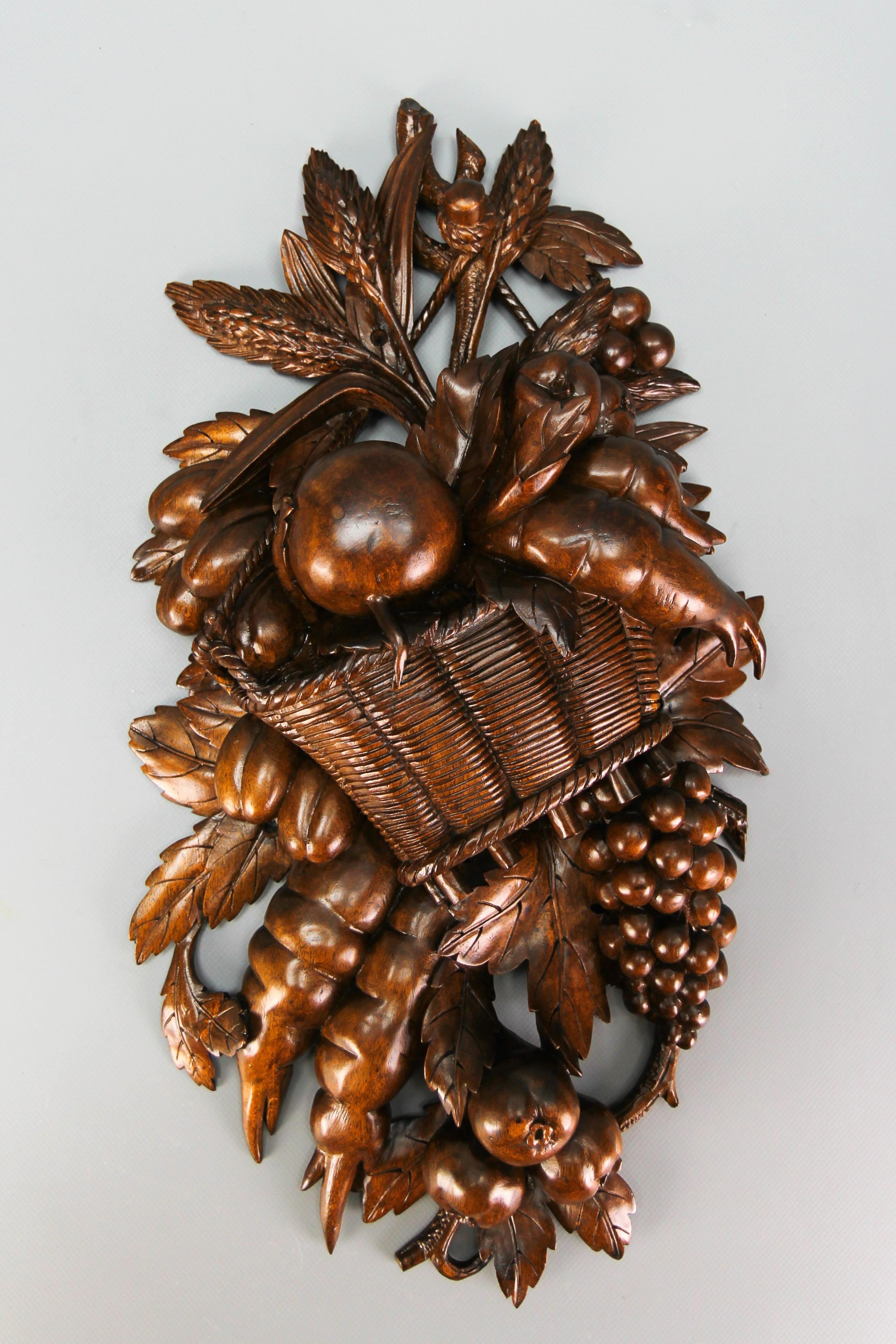 Antique hand carved walnut wall plaque fruits and vegetables, Germany, early 20th century.
This absolutely gorgeous masterfully carved wall decoration from the early 20th century features a basket with fruits, vegetables, grain, and a