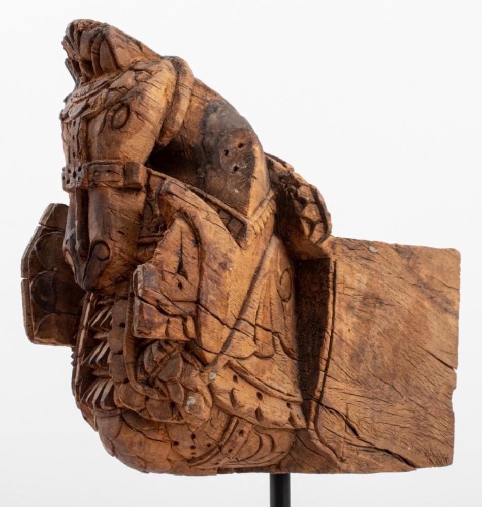 Antique, possibly Southeast Asian, hand-carved hardwood architectural element in the form of an elaborately bridled horse, now mounted on a black lacquered wood base. Overall: 17