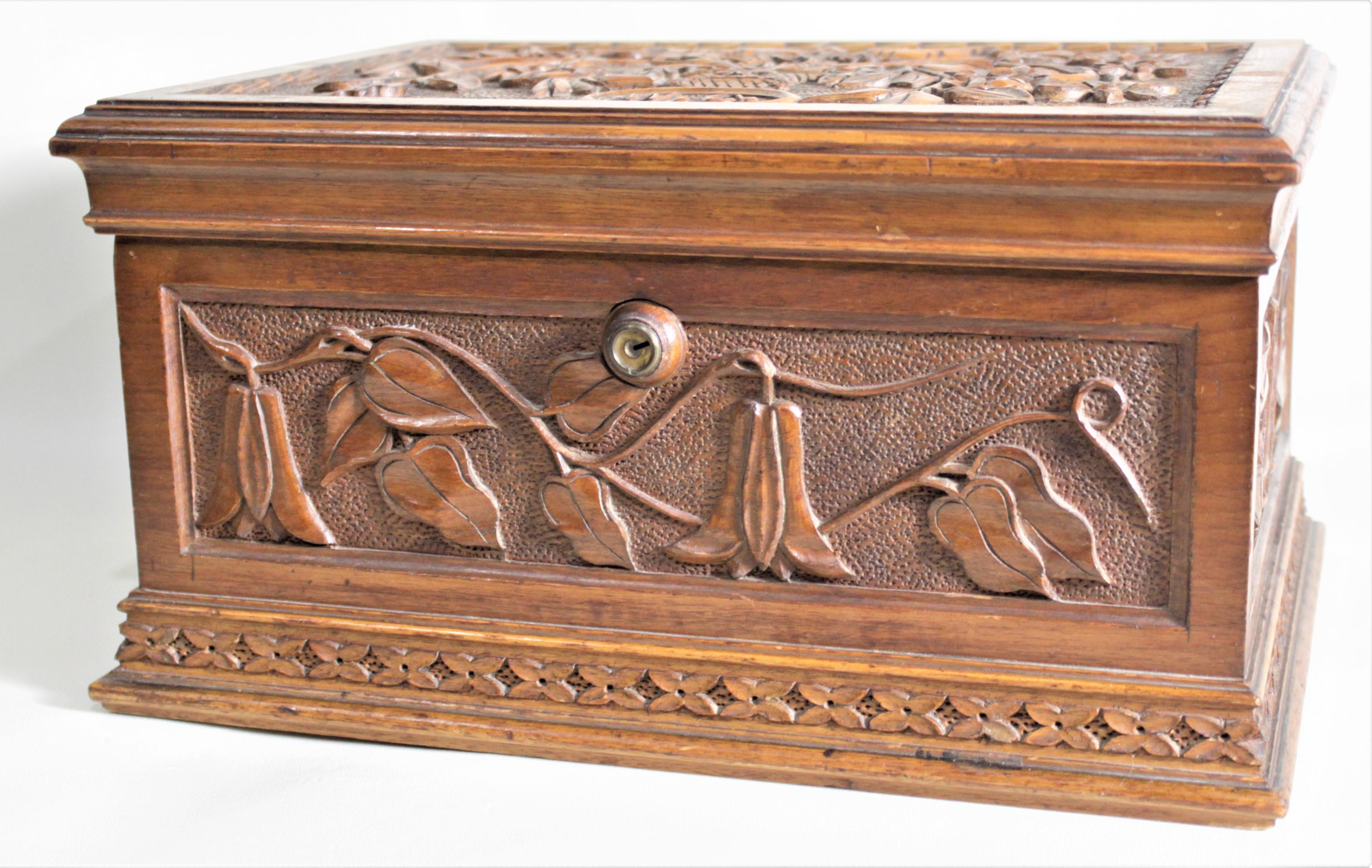 This hand carved wooden jewelry casket is unsigned but believed to have been made in England in circa 1890 in the period Art Nouveau style. The box is ornately carved on all four sides and the top and is done in very intricate panels of floral