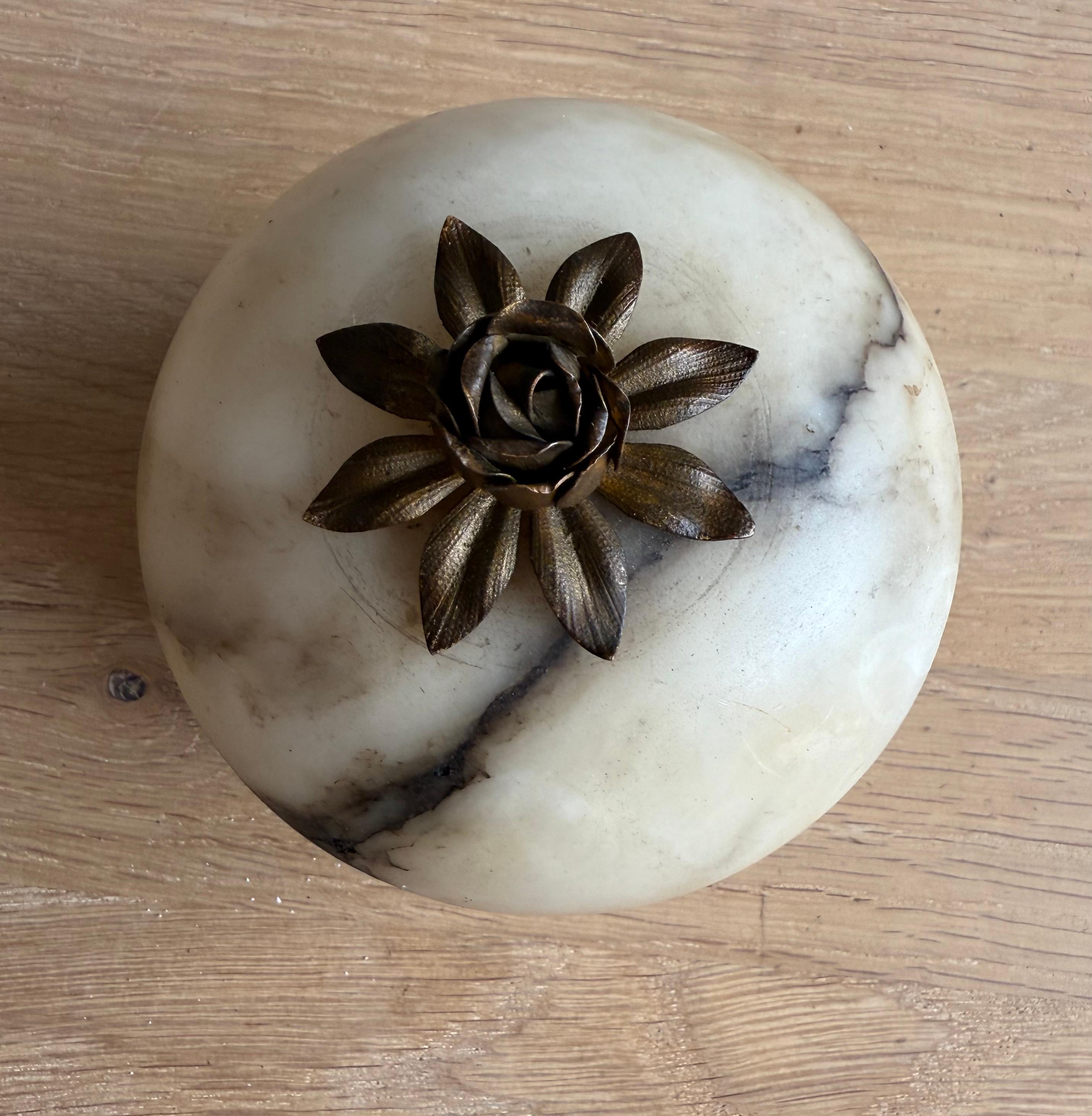 Quality made antique alabaster trinket xox with brass rose lid, romantic decor.

Beautiful antique lidded box made from alabaster, featuring a finely crafted brass rose as the handle on top. This unique piece is carefully made and showcases natural