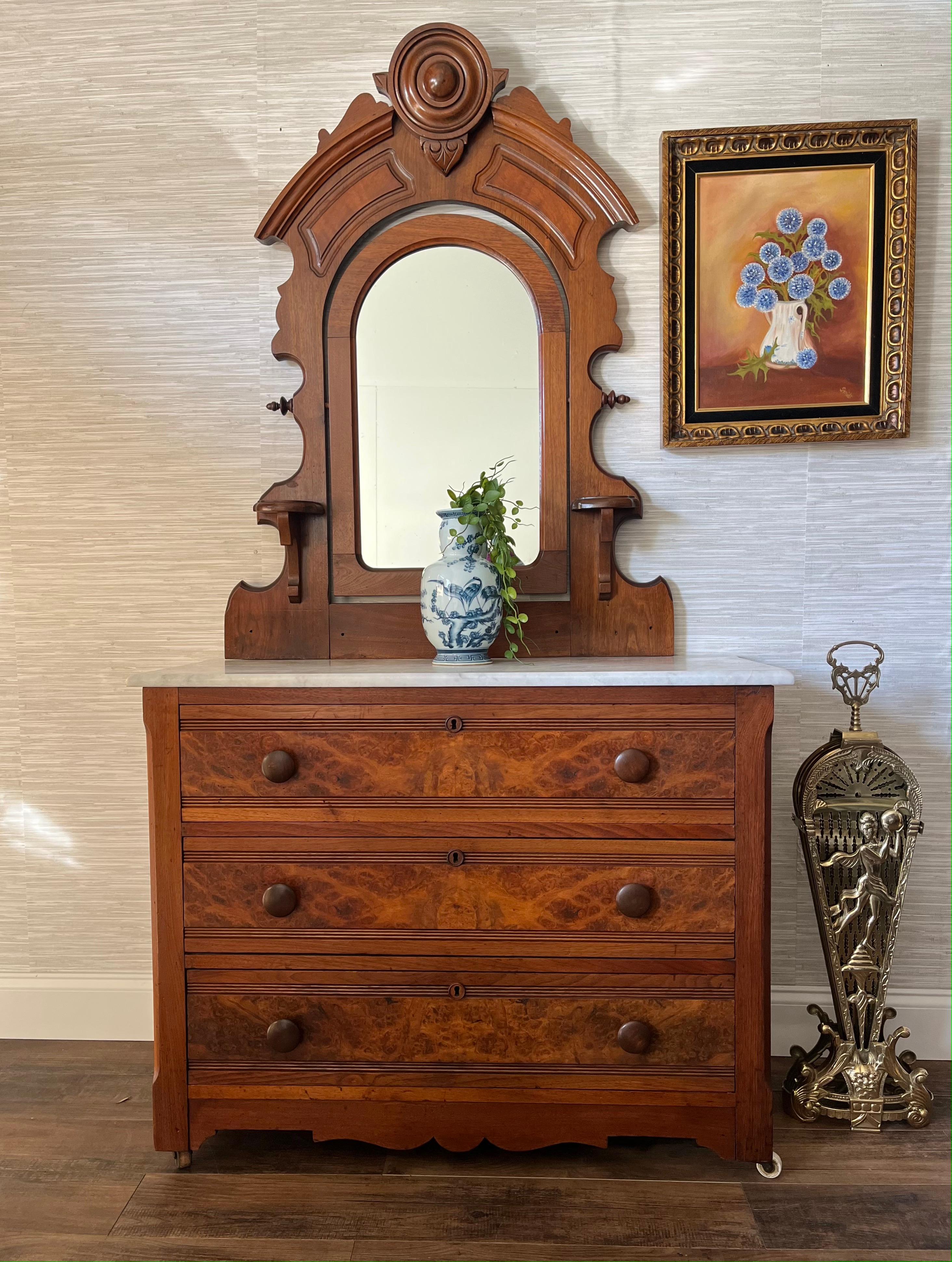 This Eastlake Victorian dresser, hailing from the early 1800s, is imbued with the refined aesthetic of its time. The dresser's burl wood veneer is indicative of its status as a piece belonging to a discerning middle to upper-middle class Victorian