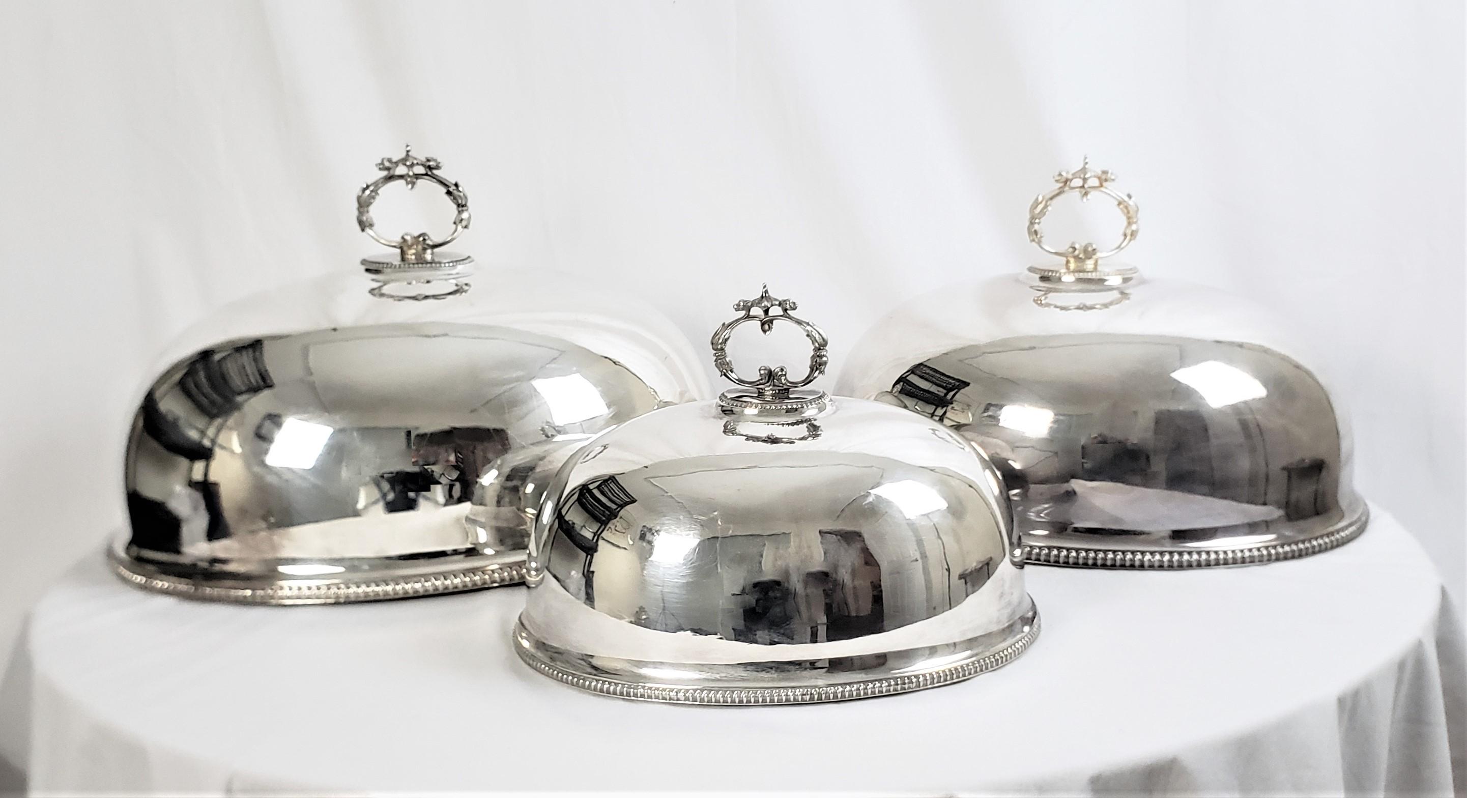 This set of antique meat domes are unsigned, but presumed to have originated from England and date to approximately 1890 and done in a period Victorian style. This graduated set of three domes have been hand-crafted and silver plated with cast and