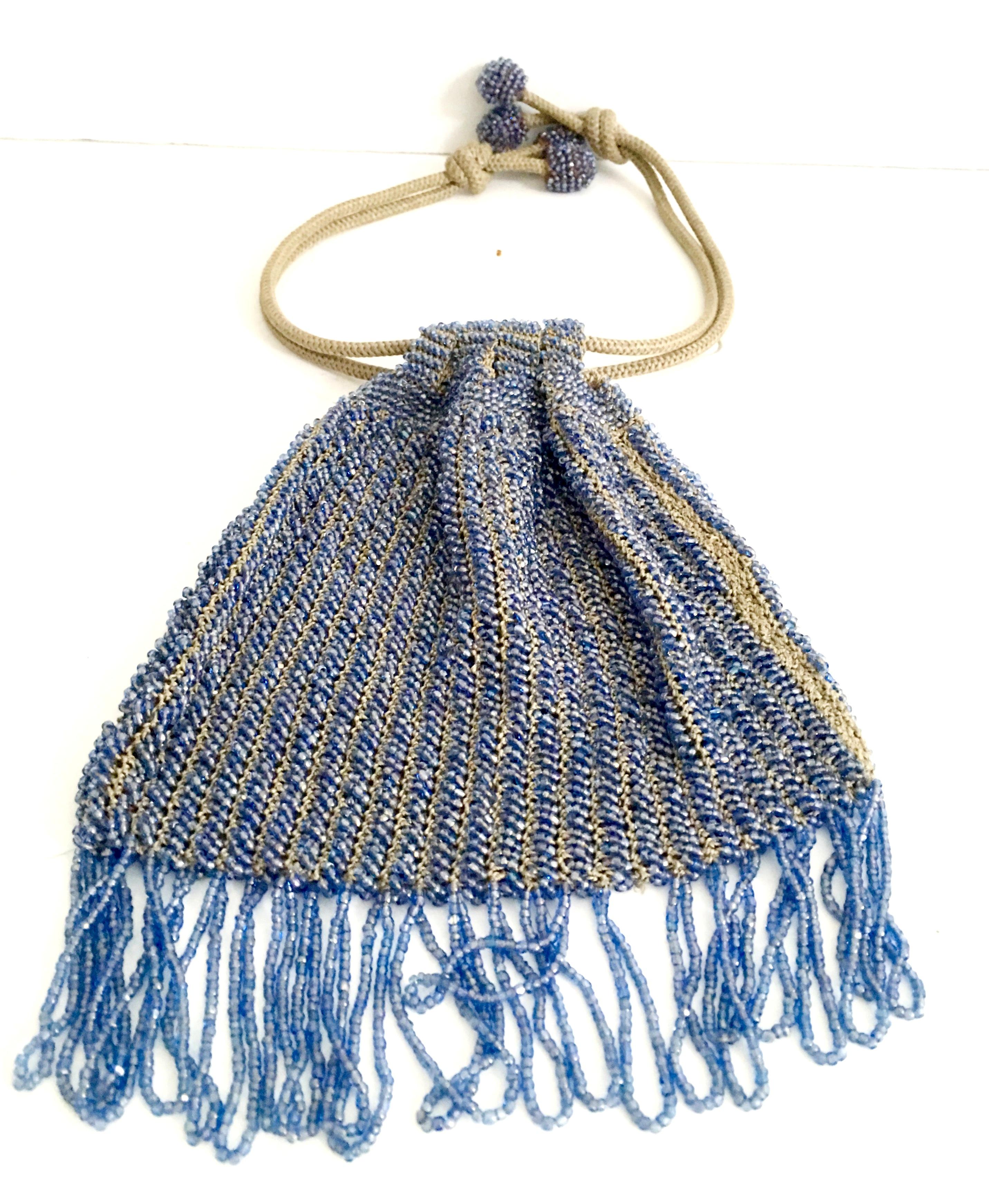 Antique Hand Cut Art Glass beaded woven crochet drawstring flapper evening bag. Executed with blue iridescent art glass beads and woven with khaki knit crochet style stitching. The drawstring is made of the same khaki color rope. Each end of the