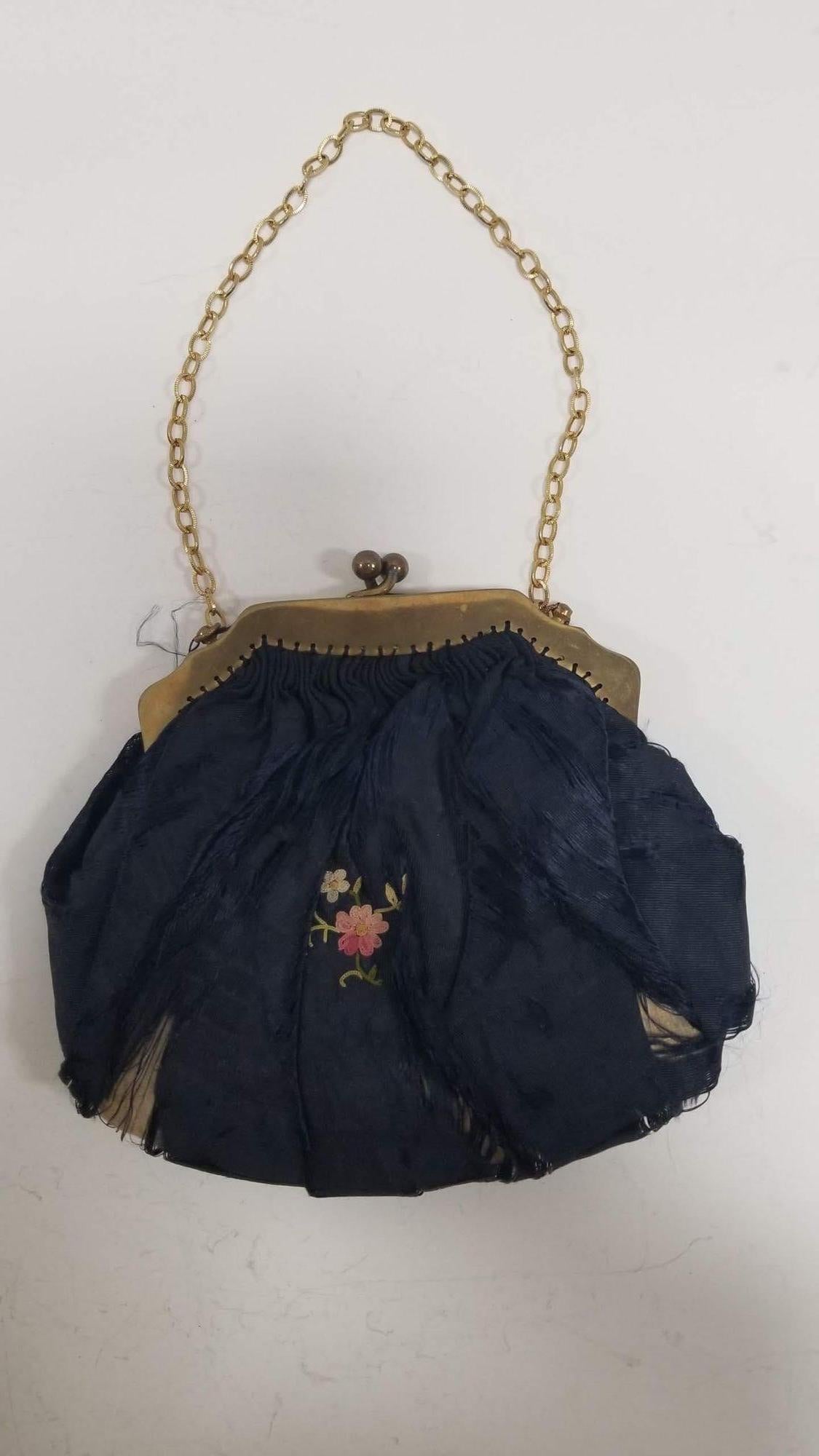 Elevate your style with this exquisite antique hand-embroidered silk purse dating back to 1910, a true testament to the craftsmanship of a bygone era. The intricate embroidery on the silk fabric reflects the artistry and attention to detail that was