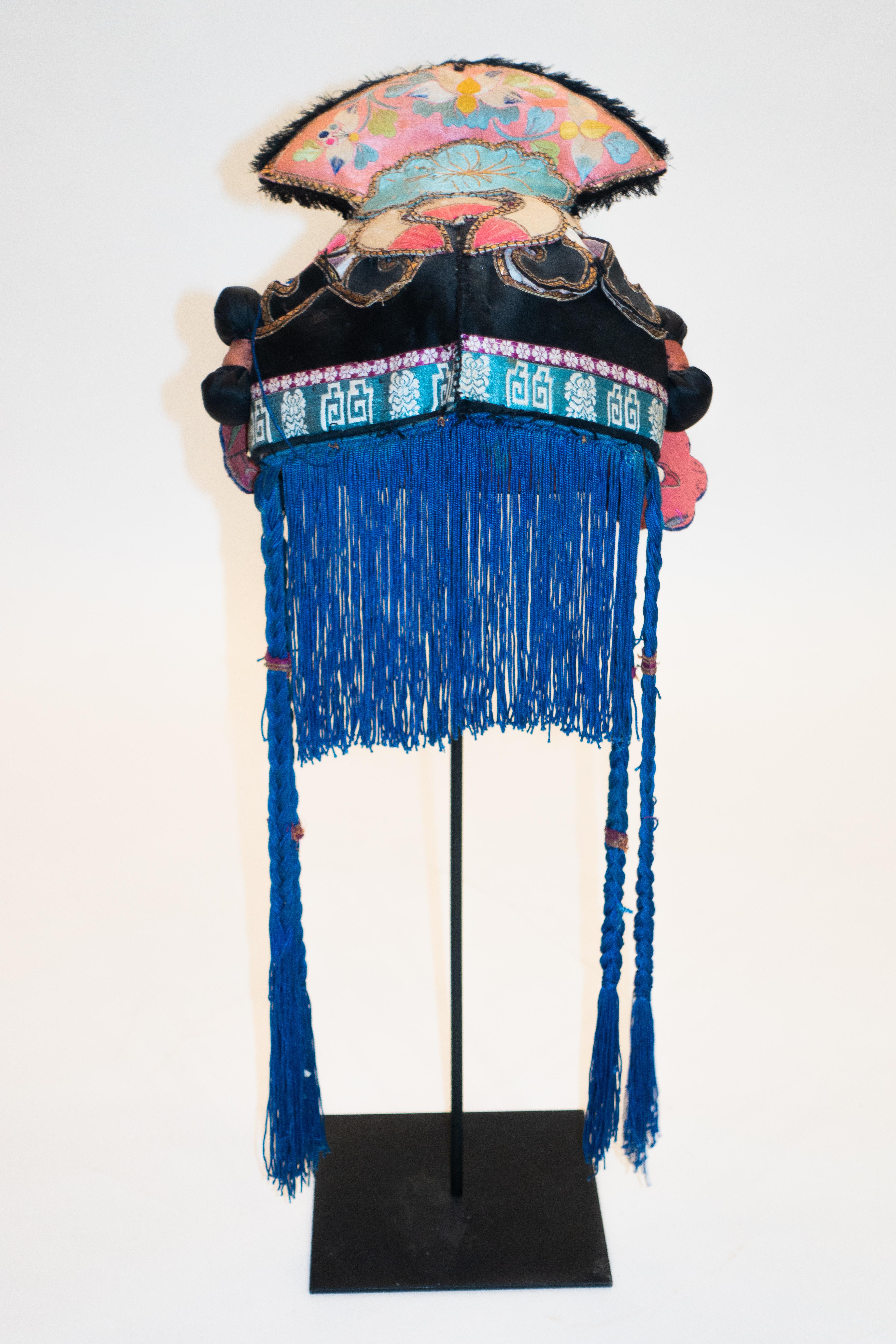 Hand embroidered silk Miao minority tribe child's headdress with inset mirrors and braided tassels from the early 20th century on a custom black painted metal mount.