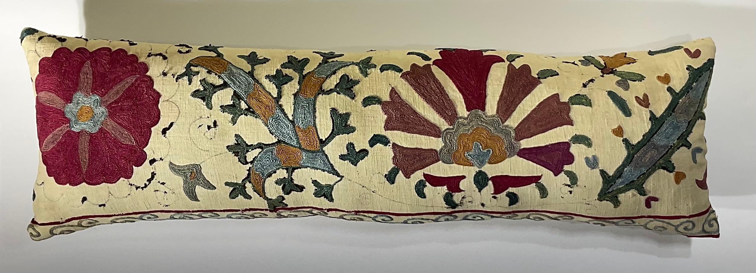 

This beautiful Suzani pillow is a true treasure, showcasing the artistry and craftsmanship of the past.  Hand embroidered with intricate floral and geometric motifs, this pillow is a testament to the skill and dedication of the artisans who
